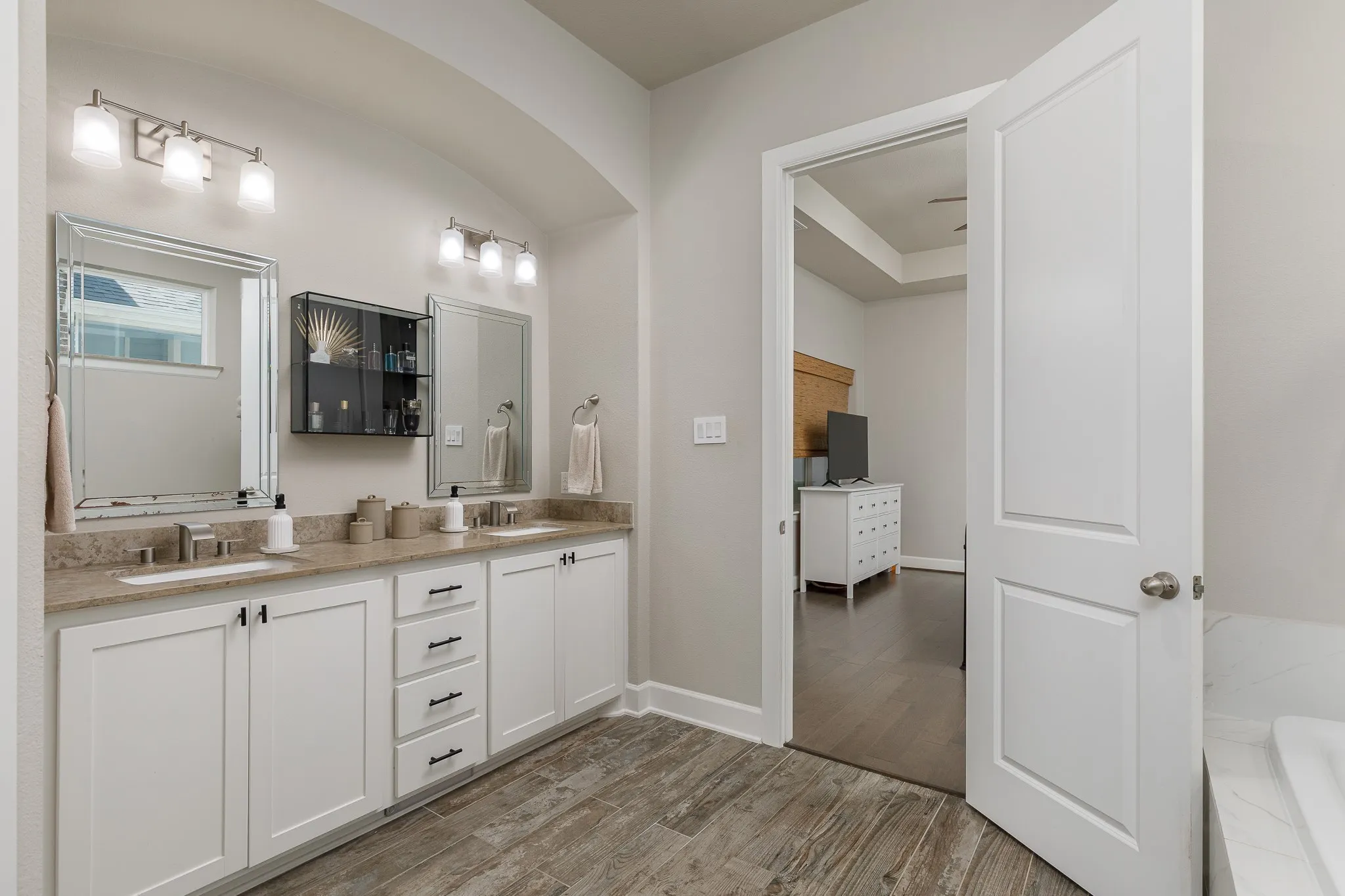 Primary bathroom with dual sinks, tub, and separate shower