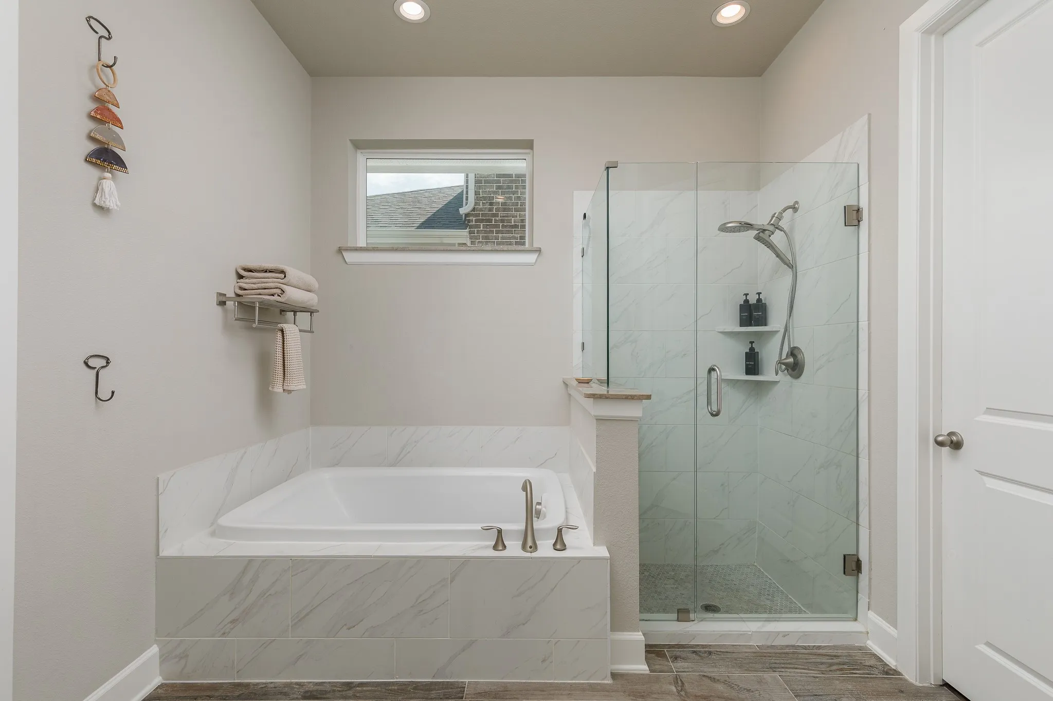 Primary bathroom with dual sinks, tub, and separate shower
