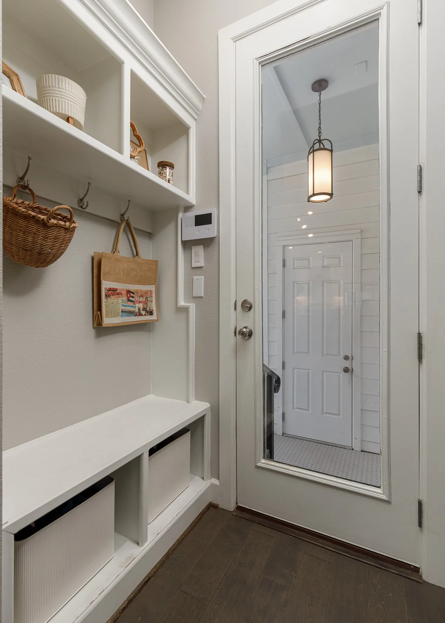 Built-in storage bench with cubbies, upper shelving, and coat hooks