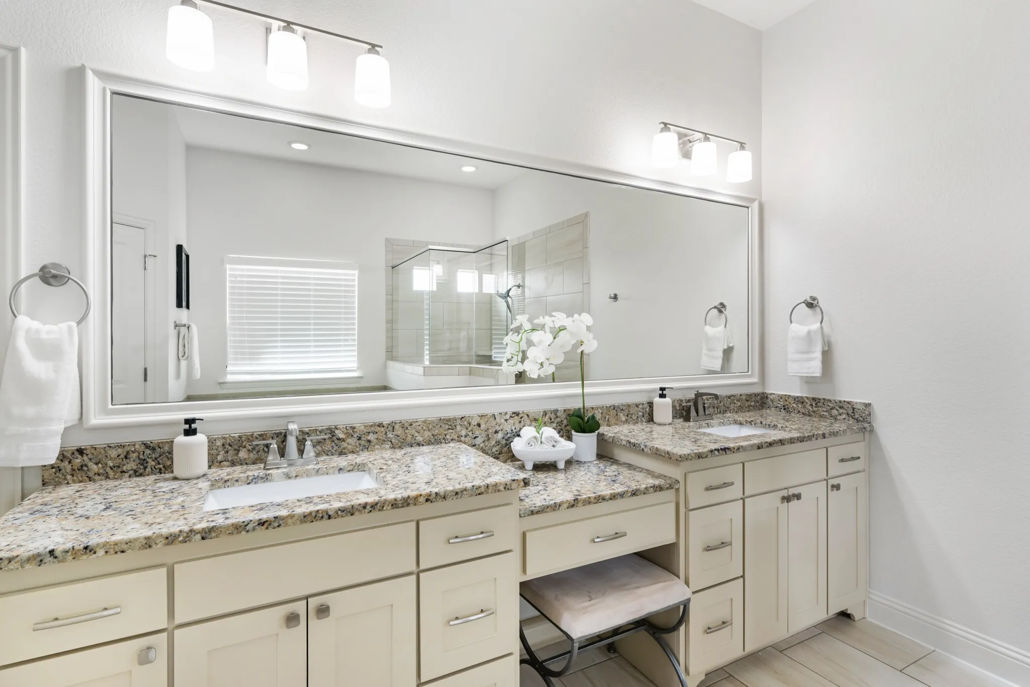 Dual vanity with granite countertops, undermount sinks, and light-toned cabinetry