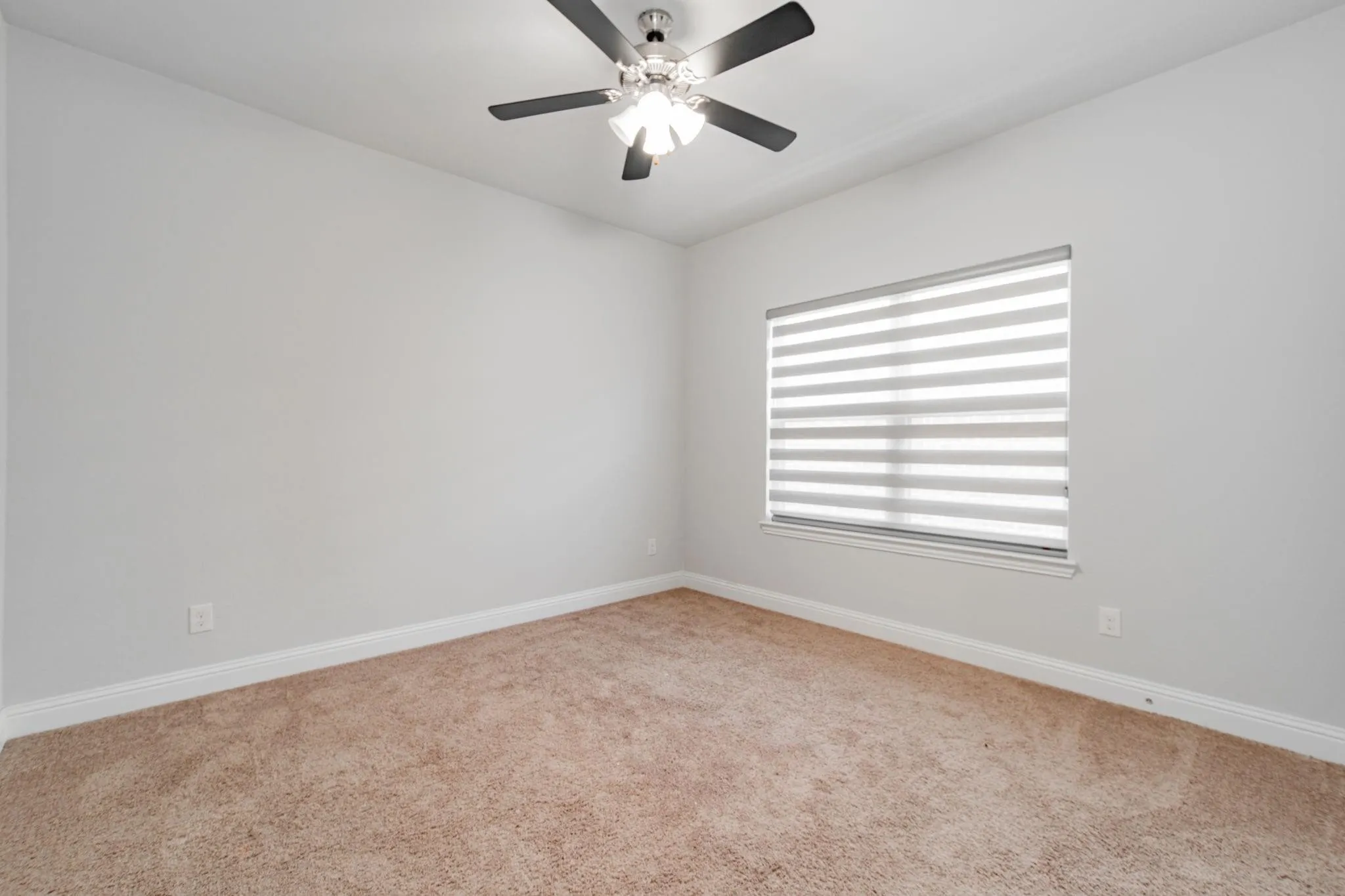 Neutral wall color, wall-to-wall carpeting, ceiling fan with light fixture, and window with horizontal blinds