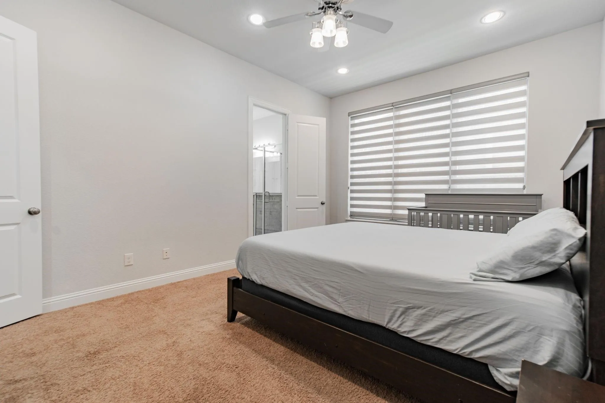 Recessed lighting, ceiling fan with light fixture, window with horizontal blinds, neutral wall paint, and carpeting