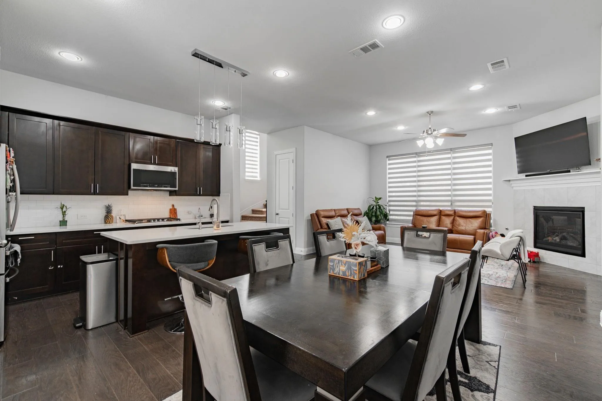 Gourmet kitchen with dark wood-finish cabinetry, stainless steel appliances, and a central island with bar seating