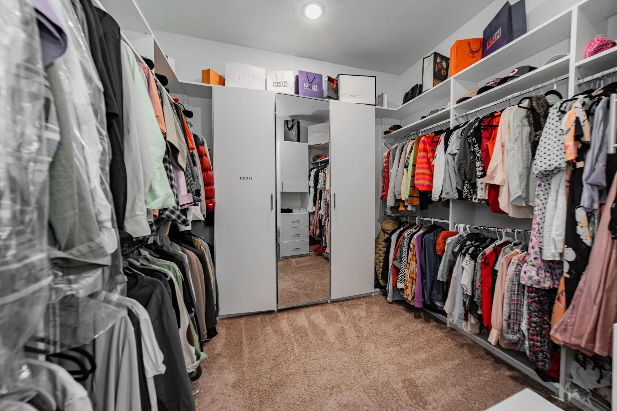 Custom closet system featuring built-in shelving, hanging rods, and an integrated full-length mirror