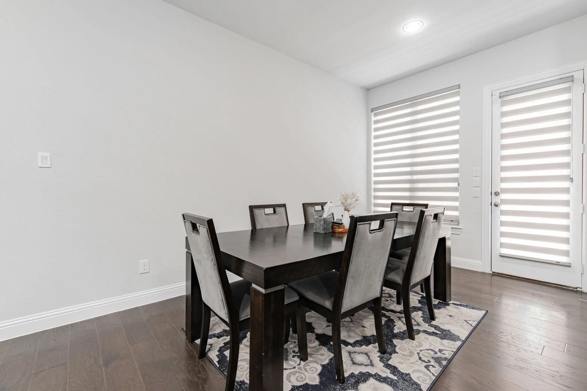 Wood-finish flooring, recessed lighting, and a white interior door