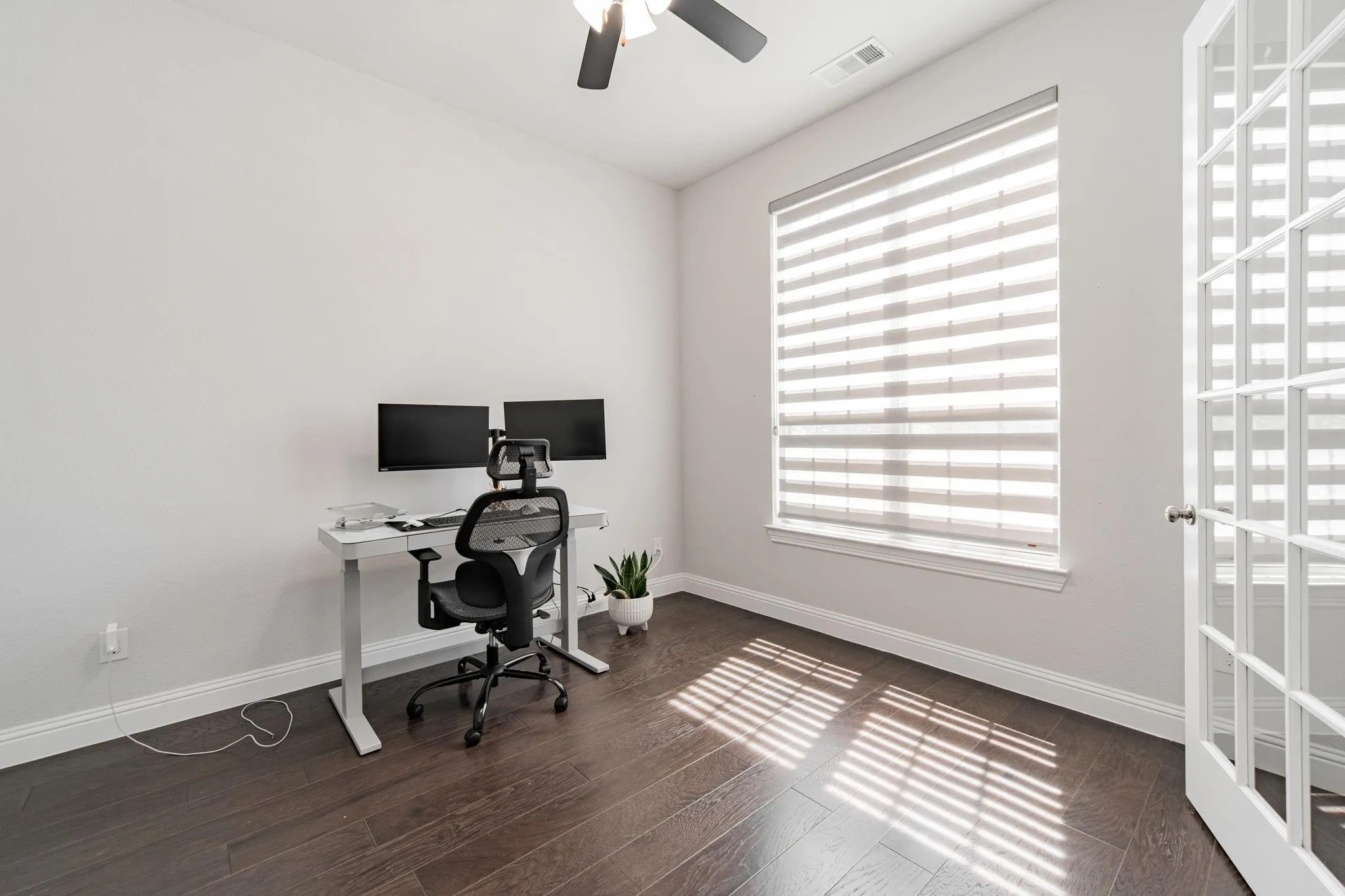 Hardwood-finish flooring, recessed lighting, ceiling fan, and French-style door