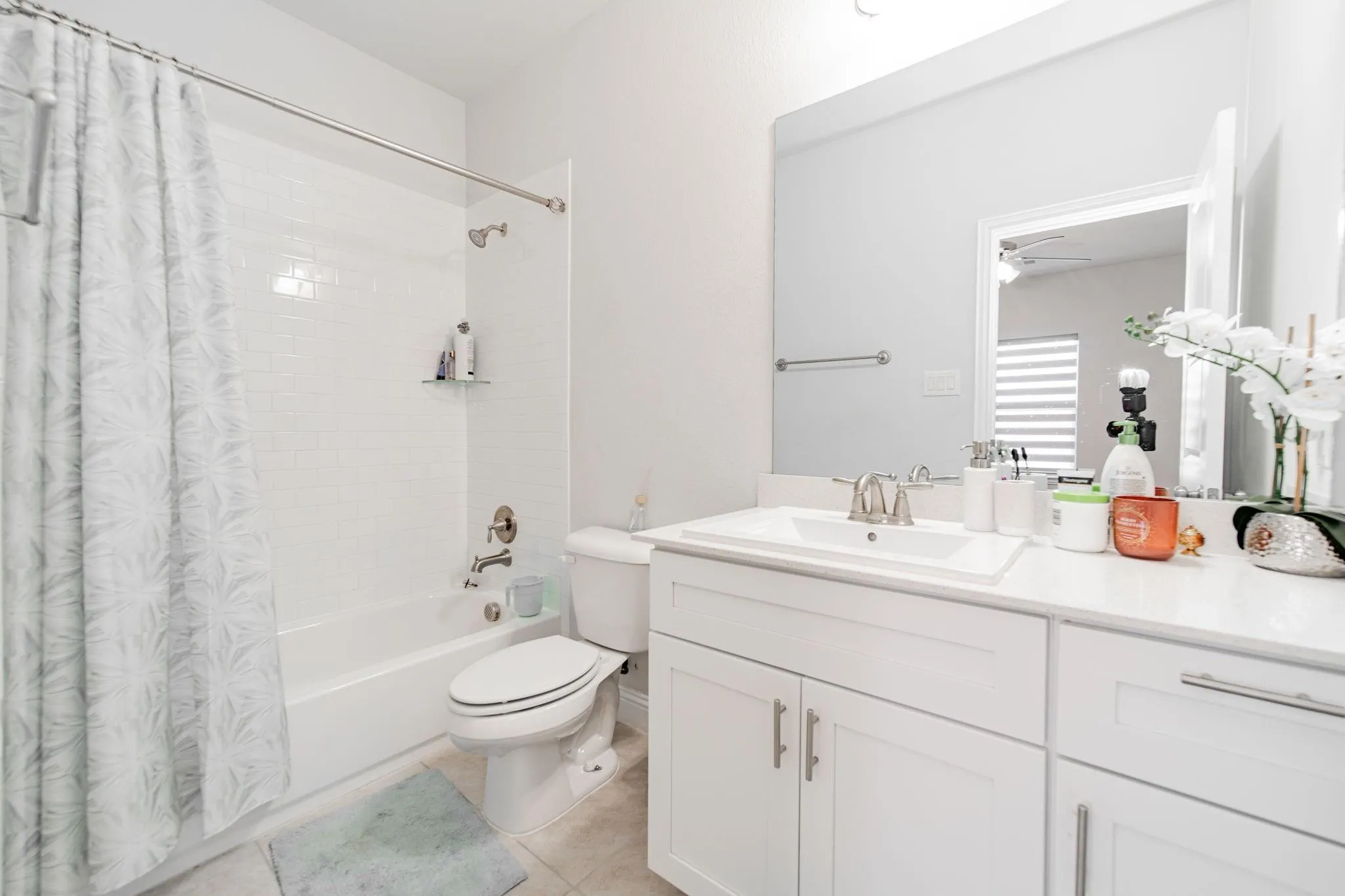 White subway tile shower surround with a built-in tub and a single vanity