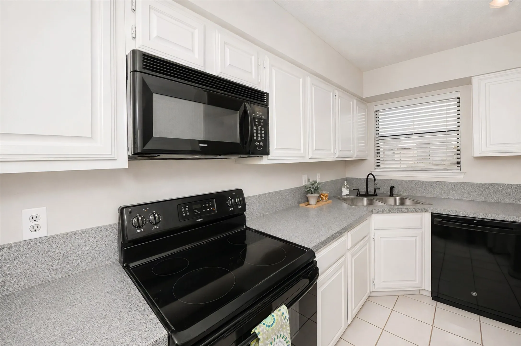 The kitchen offers a sleek black range, microwave and new dishwasher.