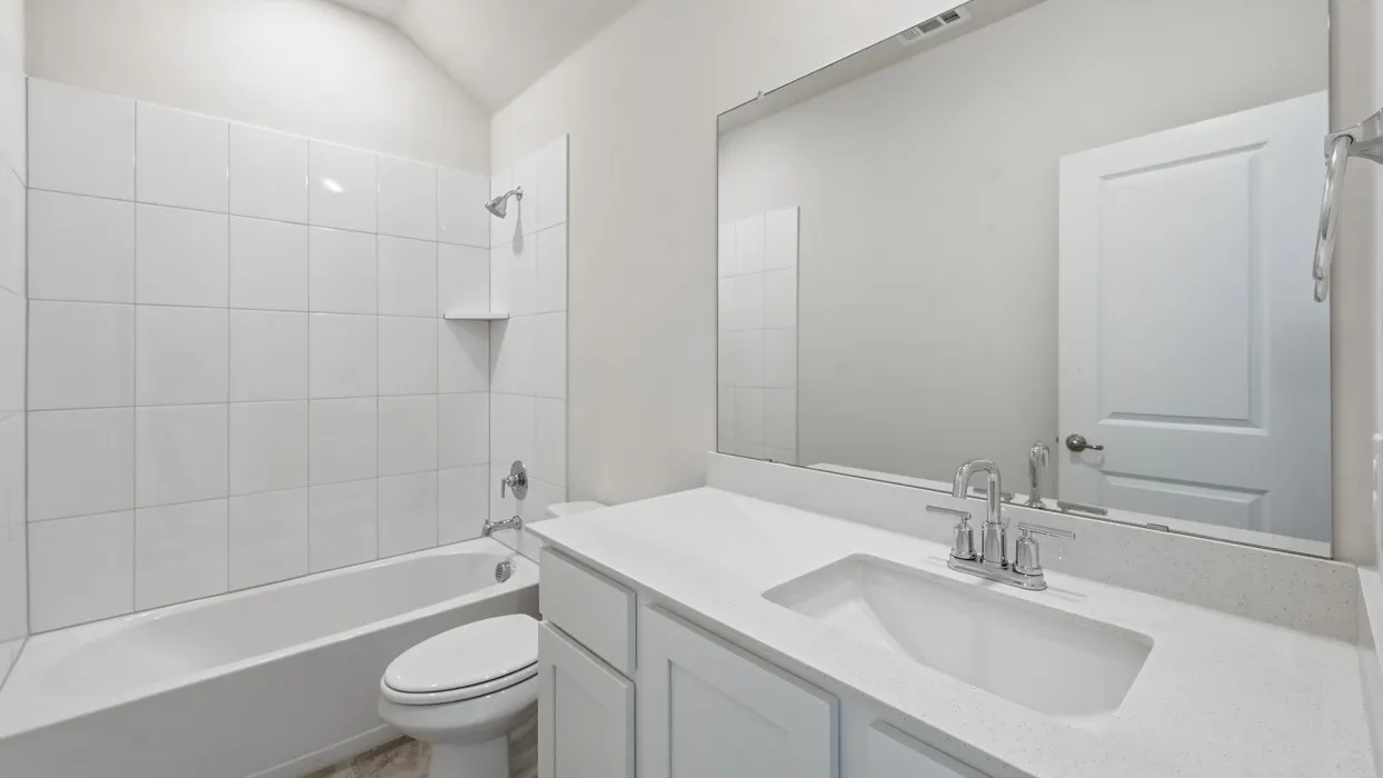Built-in bathtub with white tile surround, single vanity with integrated sink, chrome faucet, and expansive wall-mounted mirror