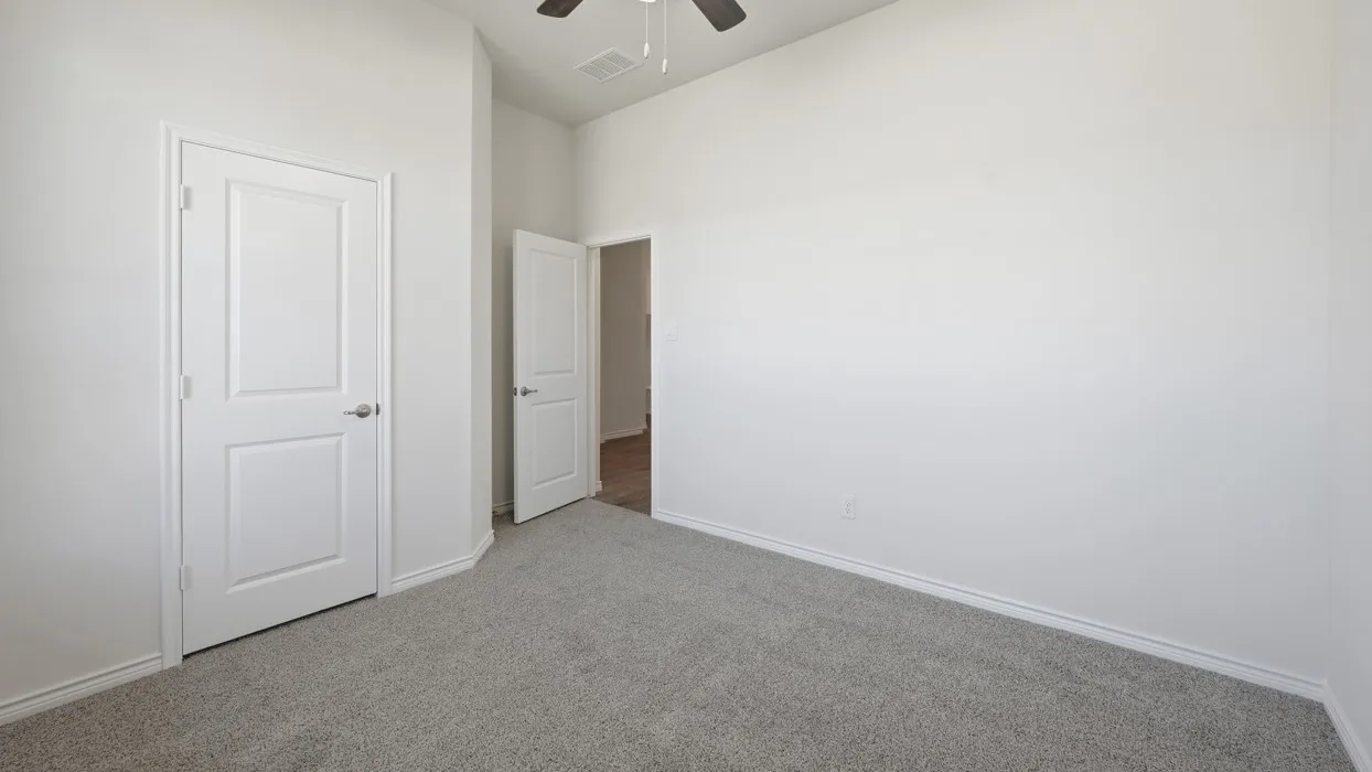 Neutral tone wall finishes, gray carpeting, modern two-panel doors, and an overhead ceiling fan