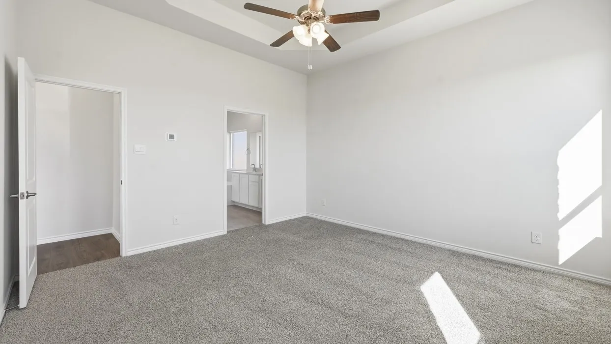 Spacious carpeted room with a vaulted ceiling and a ceiling fan