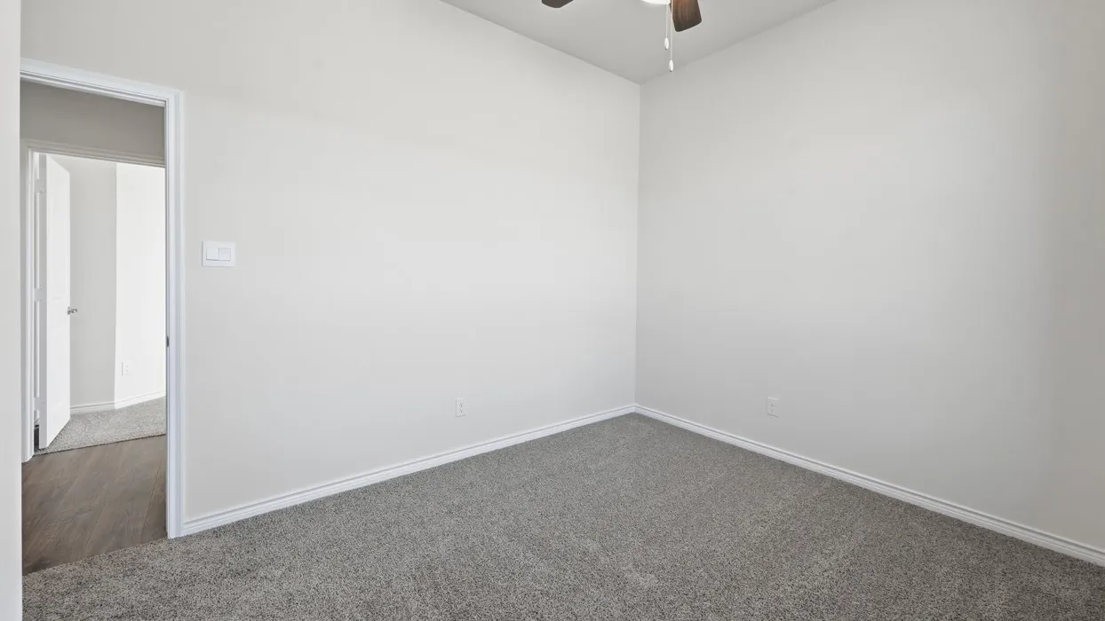 Spacious bedroom with neutral wall finishes, plush carpeting, and abundant natural light from the ceiling fixture