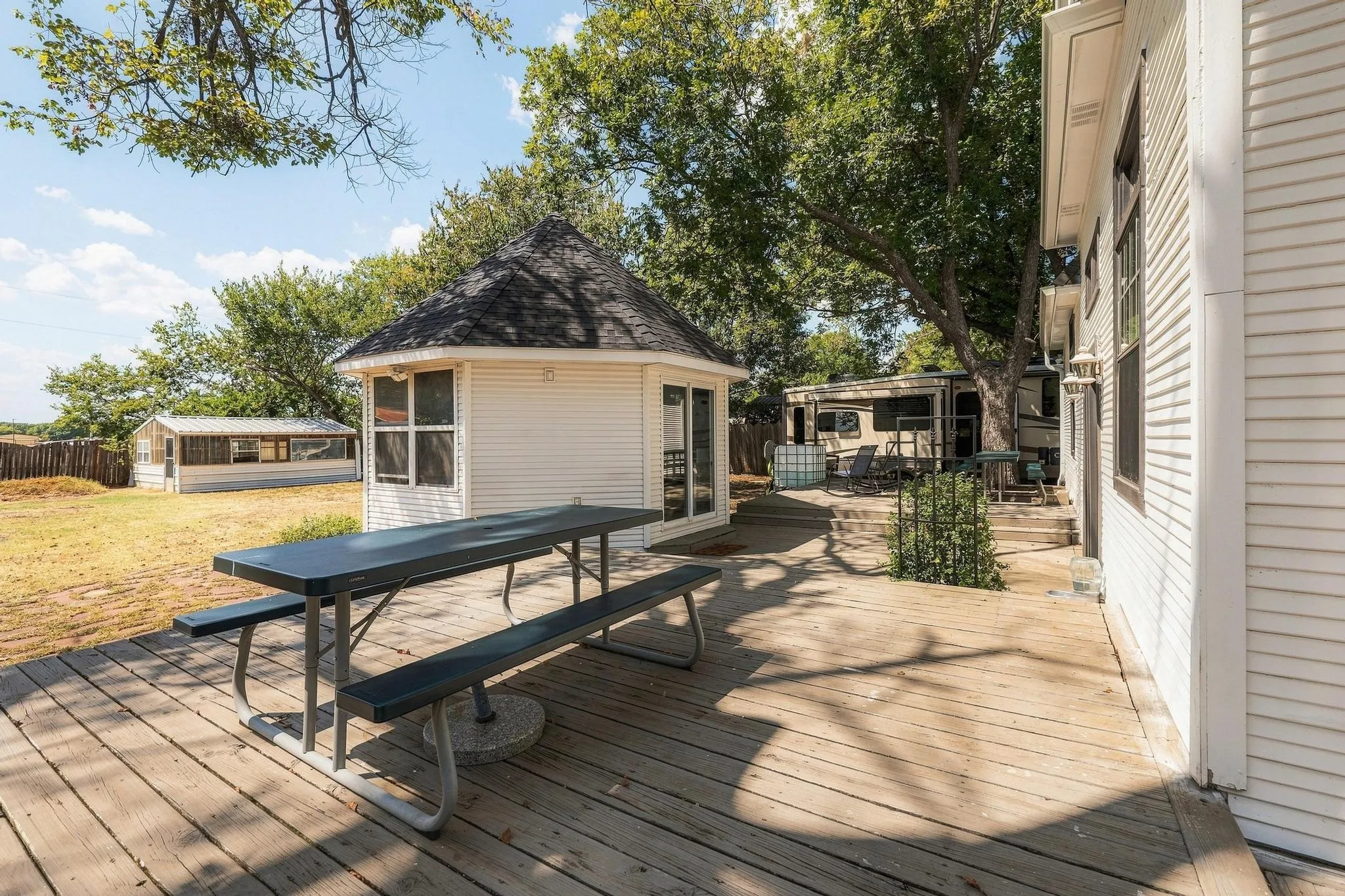 Large wood deck for entertaining with view of additional exterior round room perfect for home office or addional guest space