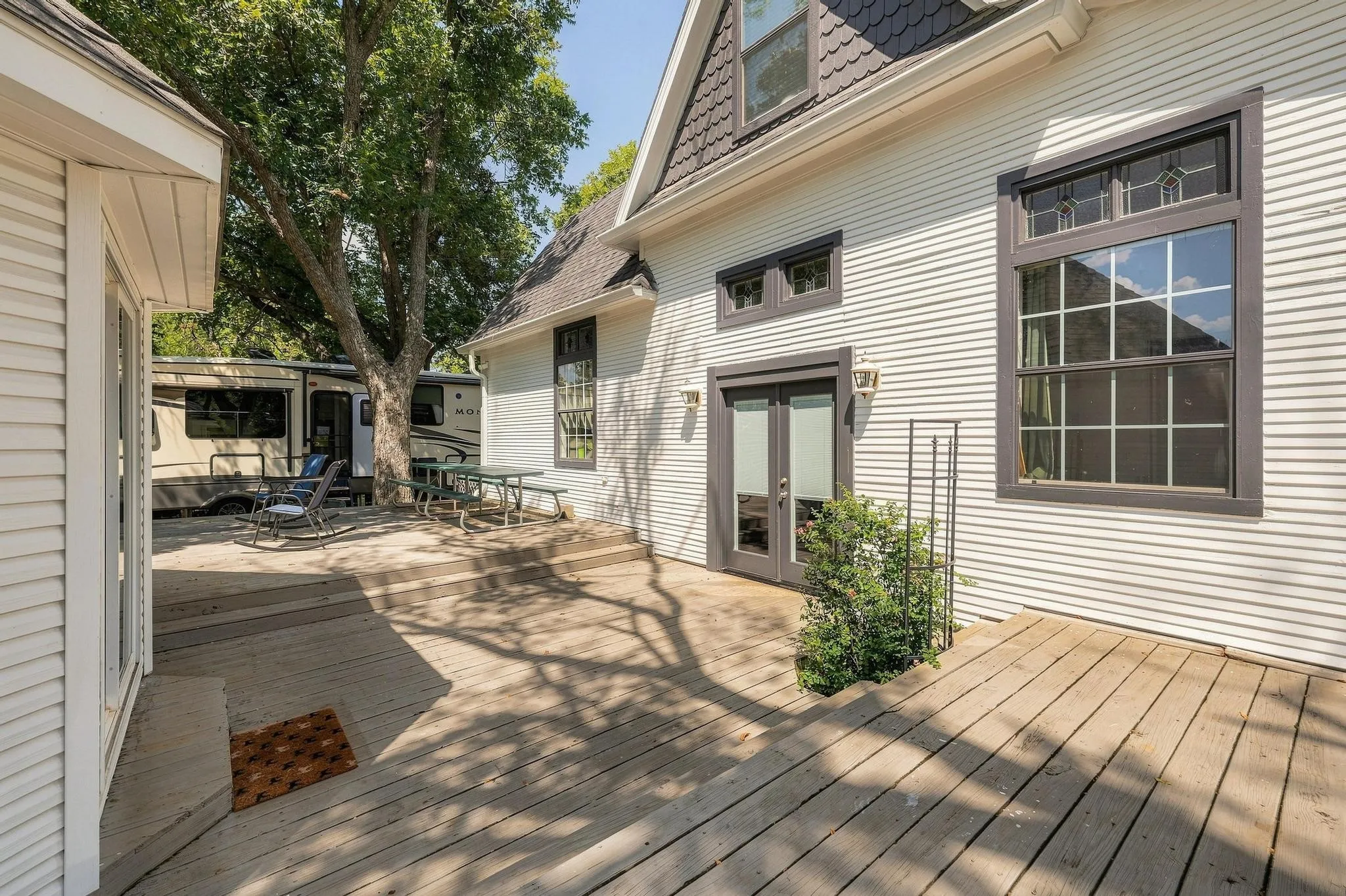 Large patio deck at the rear of home with double door access