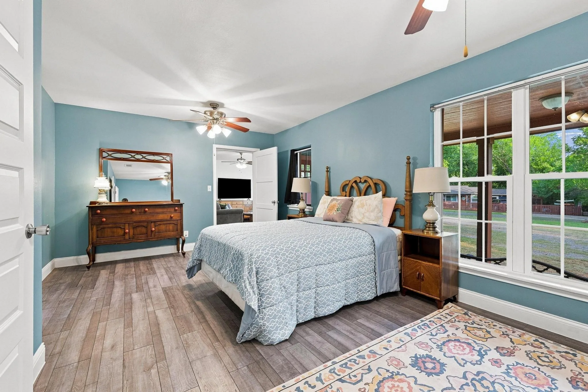 Wood-finish flooring, ceiling fan, and large window
