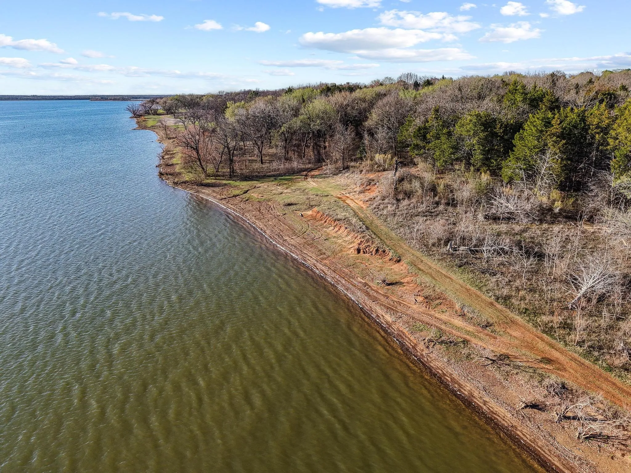 Waterfront acreage featuring natural treeline and a clear shoreline
