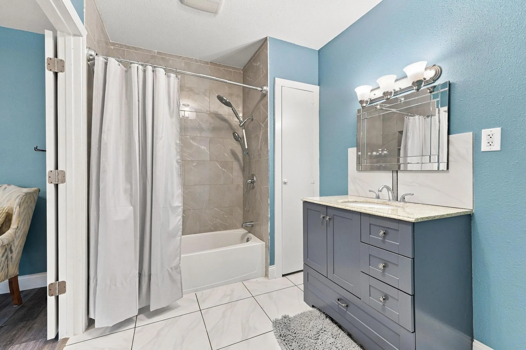 Vanity with granite countertop, integrated sink, and chrome fixtures