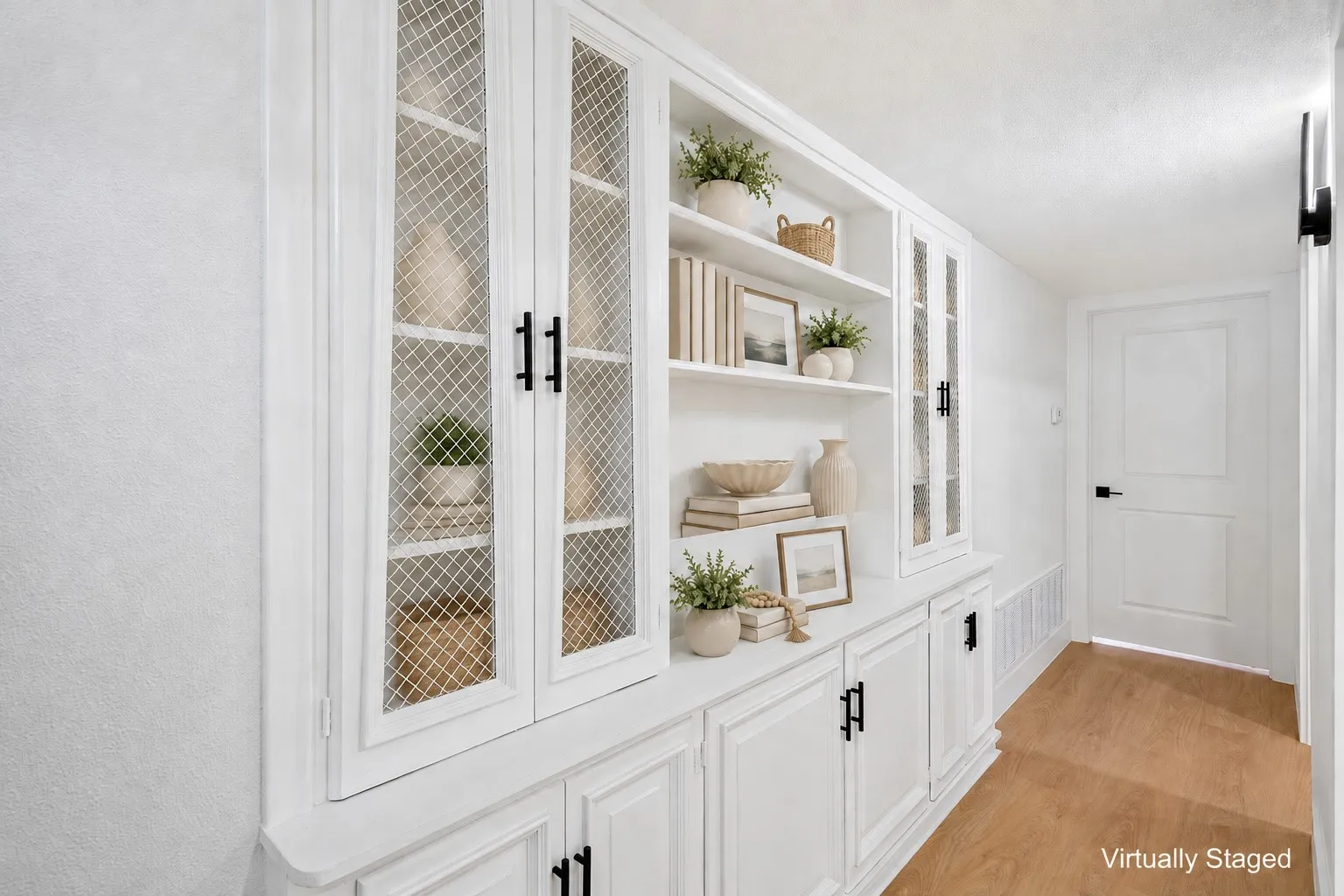 Built-in white cabinetry with glass-front upper doors, open shelving, lower storage cabinets, and matte black hardware