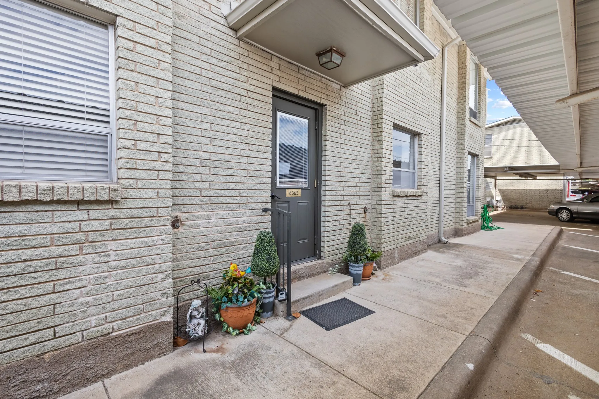 Exterior brick facade, covered entry, and covered parking area