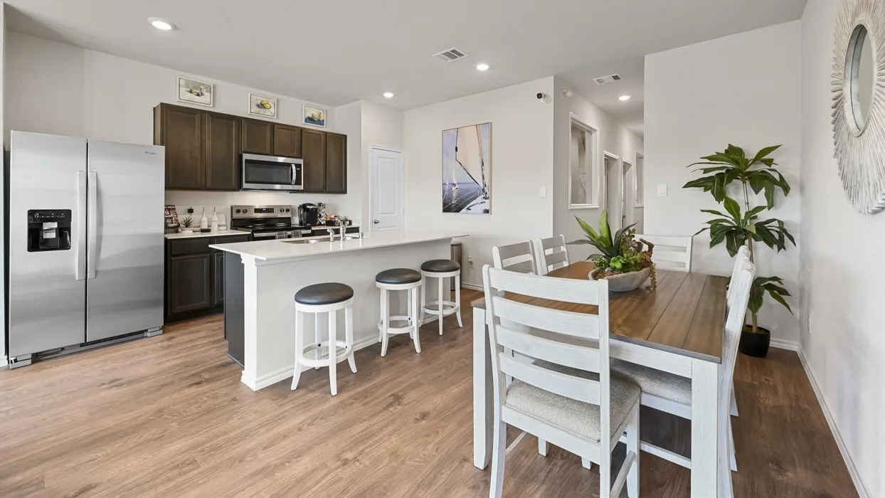 Open-concept kitchen and dining area featuring wood-finish flooring