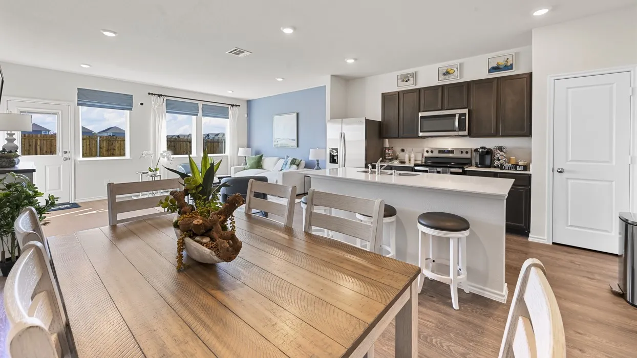 Open-concept living space featuring wood-finish flooring, recessed lighting, and multiple windows