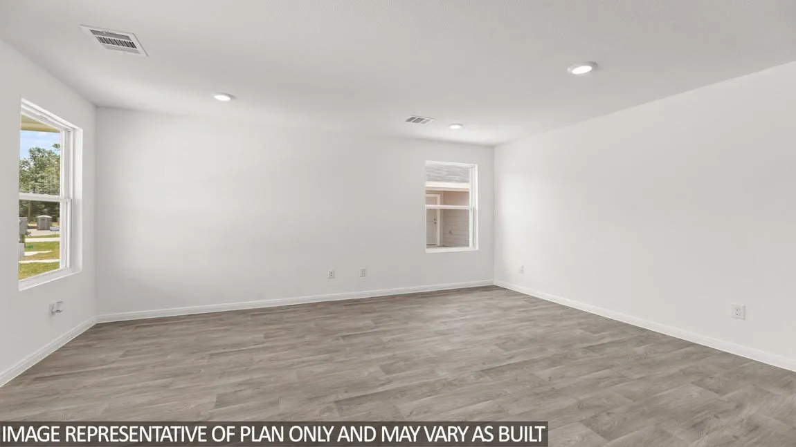 Spacious room with wood-finish flooring, recessed lighting, and multiple windows