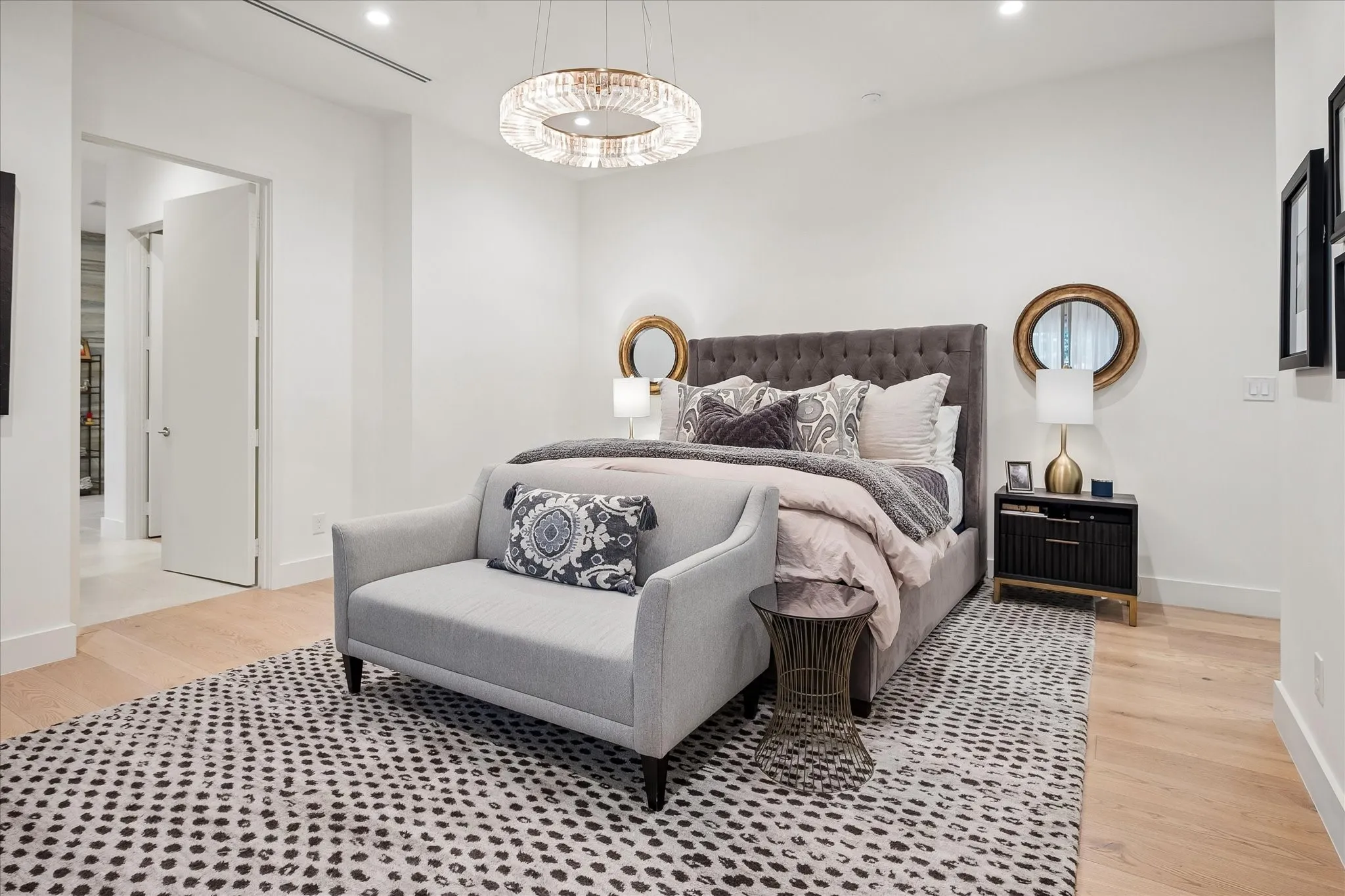 Spacious primary suite offers dual closets plus custom cabinets and designer chandelier