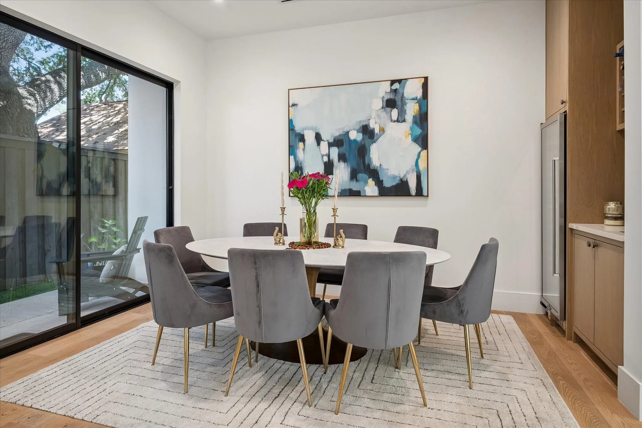 Dry Bar with Wine Refrigerator, built-in cabinets and sliding door leading to patio and outdoor grill area
