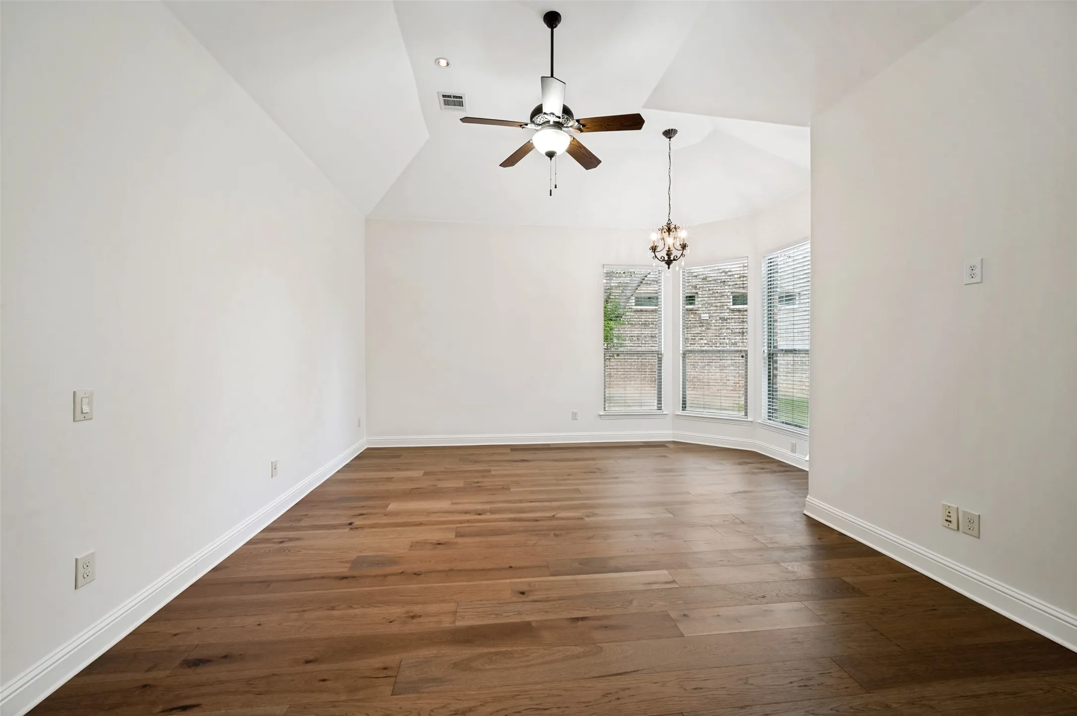 Escape to the spacious primary suite, featuring soaring vaulted ceilings, rich hardwood floors, abundant natural light, and a charming sitting area framed by beautiful bay windows. The private retreat offers direct access to the luxurious ensuite bath, creating the perfect space to relax and unwind.