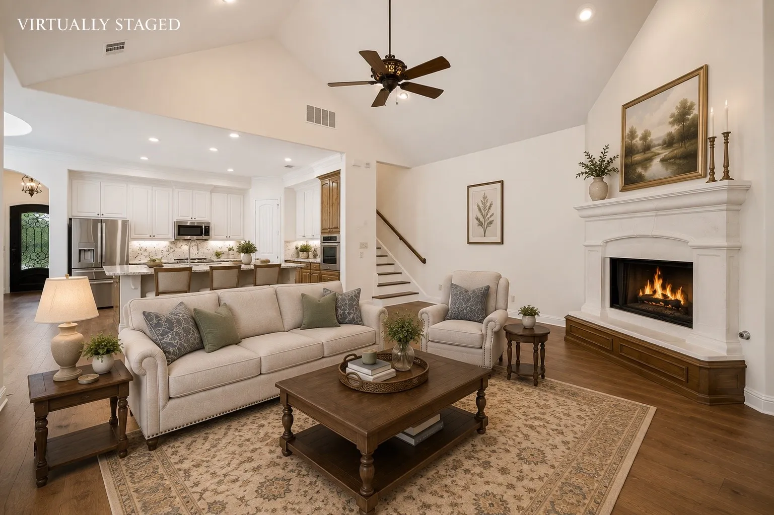 Designed for effortless entertaining, this open-concept living space seamlessly connects the family room and gourmet kitchen, featuring soaring vaulted ceilings, rich hardwood floors, a stunning cast stone fireplace, and an oversized island perfect for gathering with family and friends.
