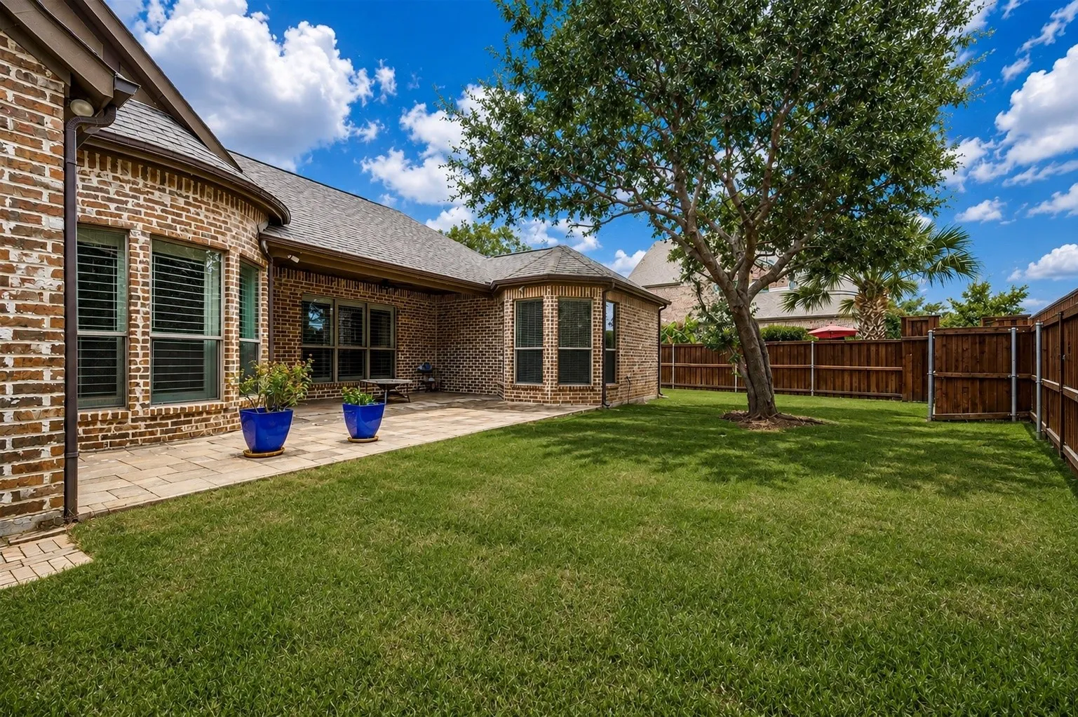 Step outside to a beautifully landscaped backyard featuring a spacious covered patio, mature shade trees, and plenty of lush green space for outdoor entertaining, family gatherings, or simply relaxing in your own private oasis.