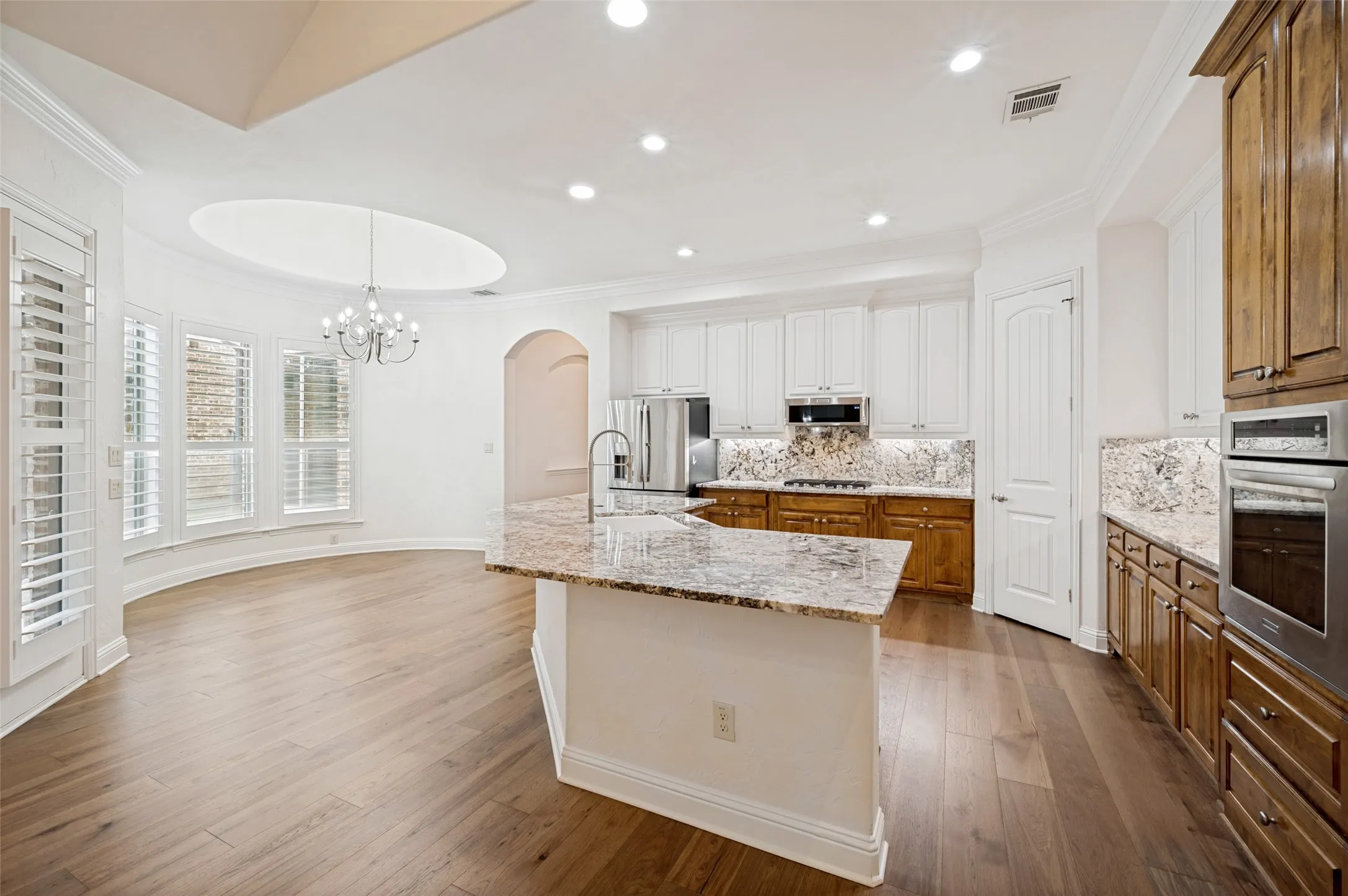 The heart of the home is this beautifully renovated gourmet kitchen, featuring all-new stainless steel appliances, custom cabinetry, granite countertops, a designer tile backsplash, double ovens, a spacious center island with seating, and a walk-in pantry. The open-concept layout flows seamlessly into the breakfast nook, making it ideal for entertaining and everyday living.