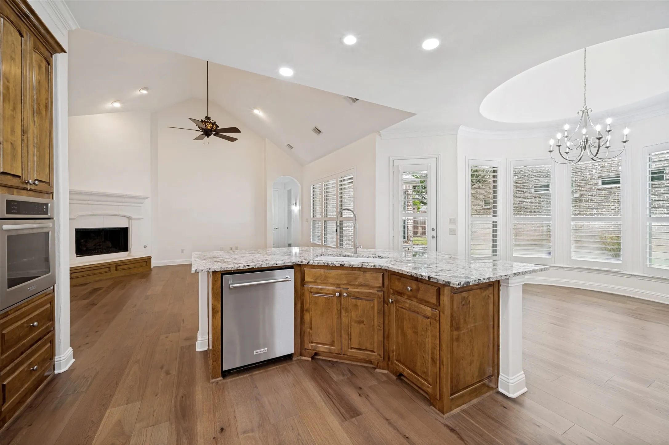 The gourmet kitchen is beautifully appointed with all-new stainless steel appliances, abundant custom cabinetry, granite countertops, a designer tile backsplash, a spacious center island with seating, and an open-concept layout that flows seamlessly into the breakfast nook and family room—perfect for entertaining and everyday living.