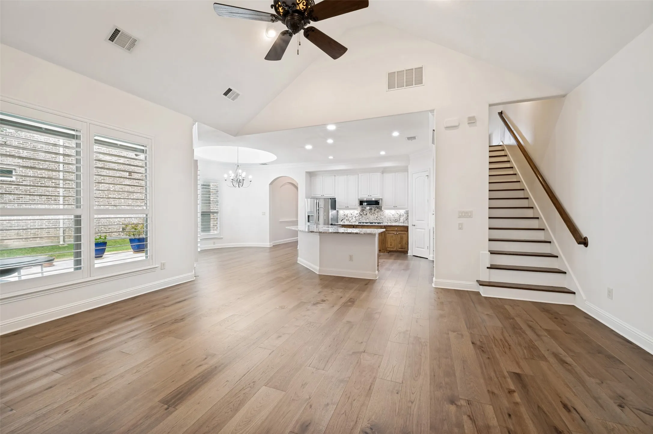 The heart of the home features an open-concept design with soaring vaulted ceilings, rich hardwood floors, a spacious gourmet kitchen with a large center island, and seamless flow into the breakfast nook and family room—perfect for everyday living and entertaining.