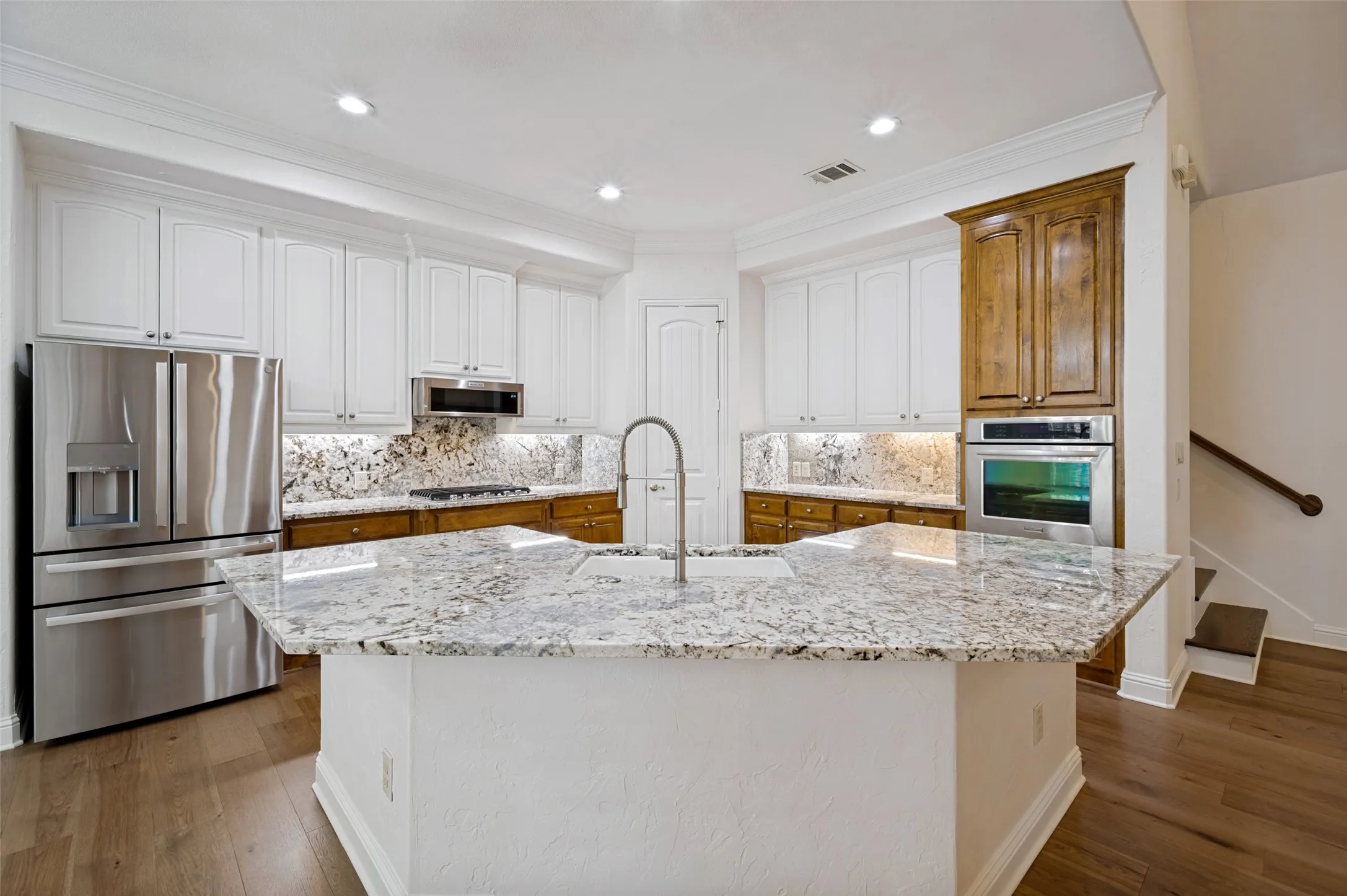 Designed with both beauty and functionality in mind, this stunning gourmet kitchen showcases all-new stainless steel appliances, gorgeous granite countertops, a designer tile backsplash, custom cabinetry, double ovens, a gas cooktop, and an oversized center island with prep sink and seating—creating the perfect space for entertaining and everyday living.