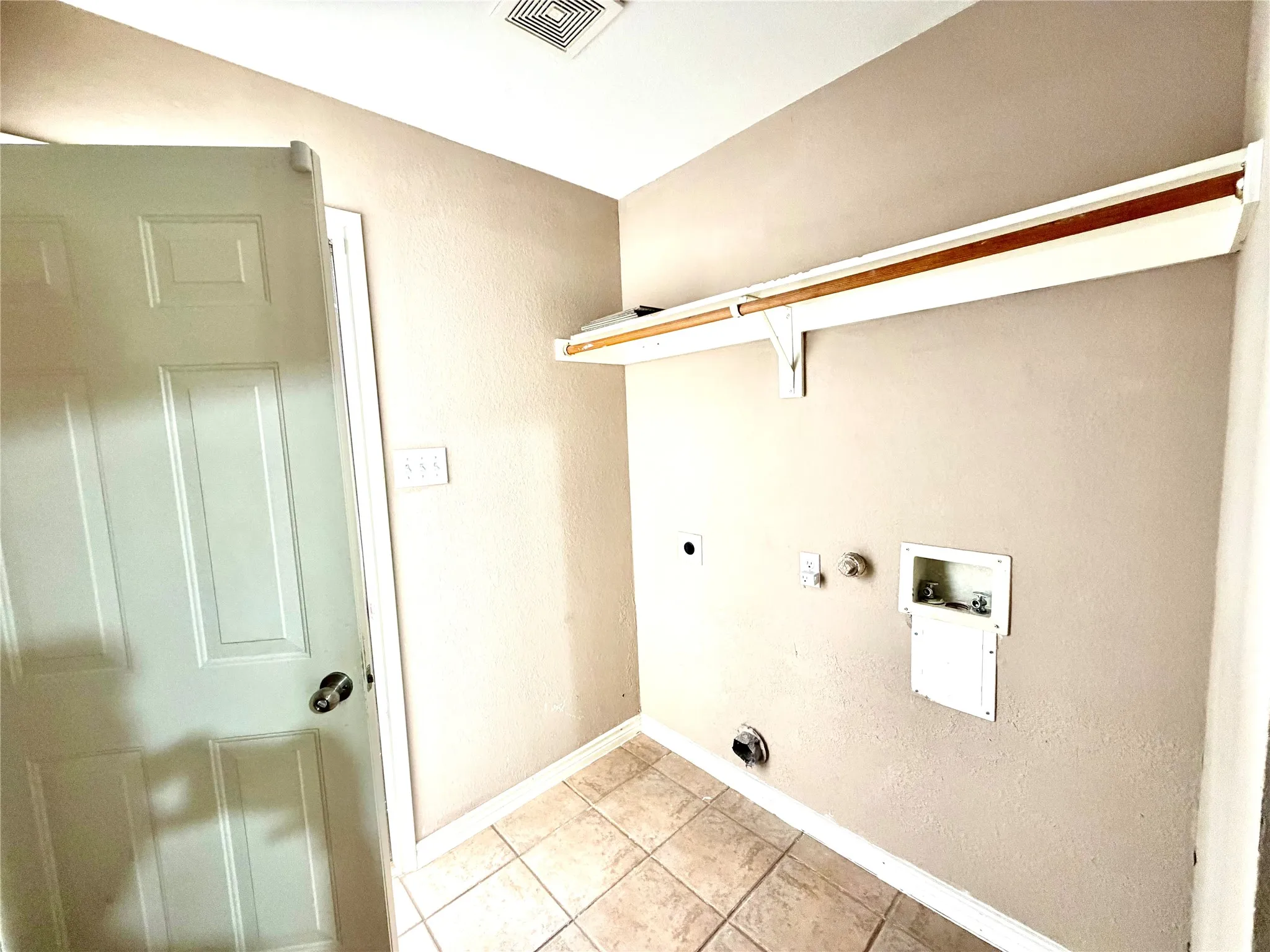 Laundry area with tile flooring and a built-in shelving unit