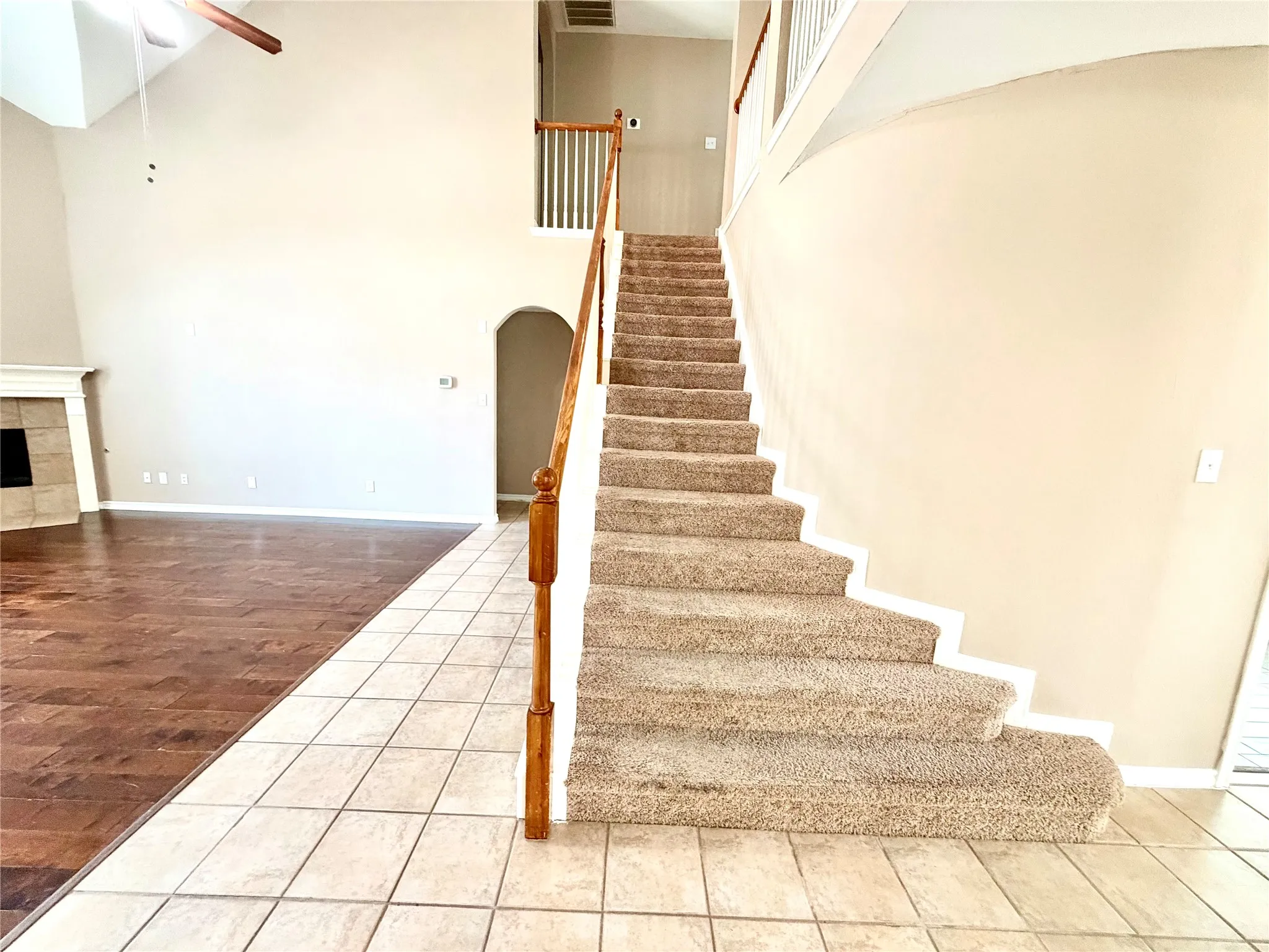 Two-story foyer with carpeted staircase and wood-finish handrail