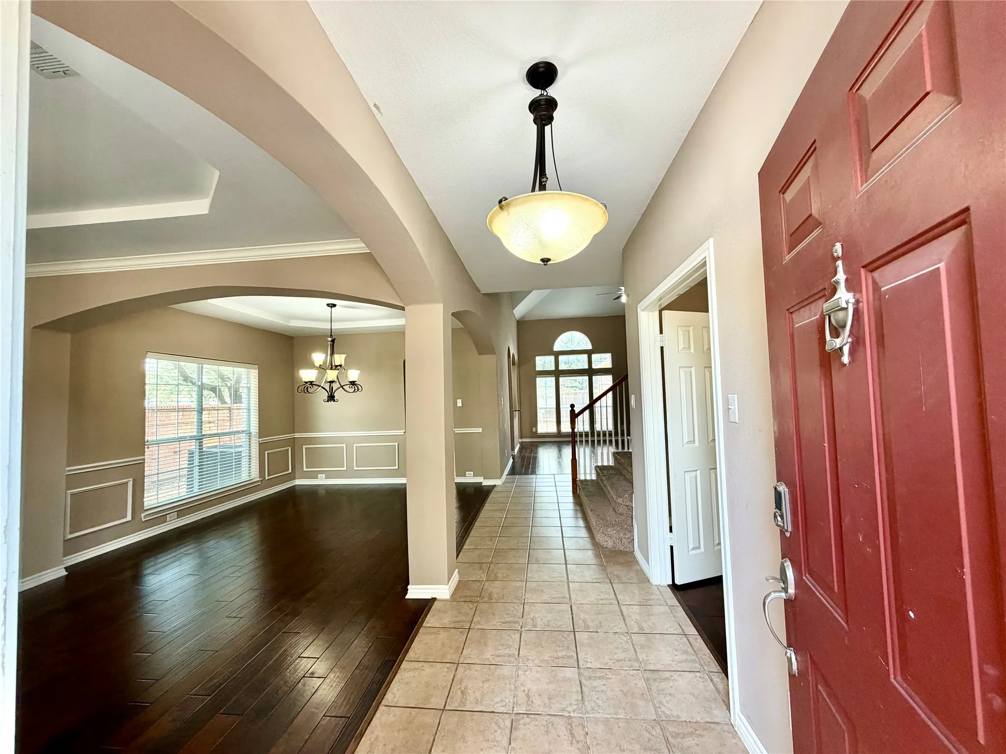 Entryway featuring tile flooring, a red paneled door, and an overhead light fixture