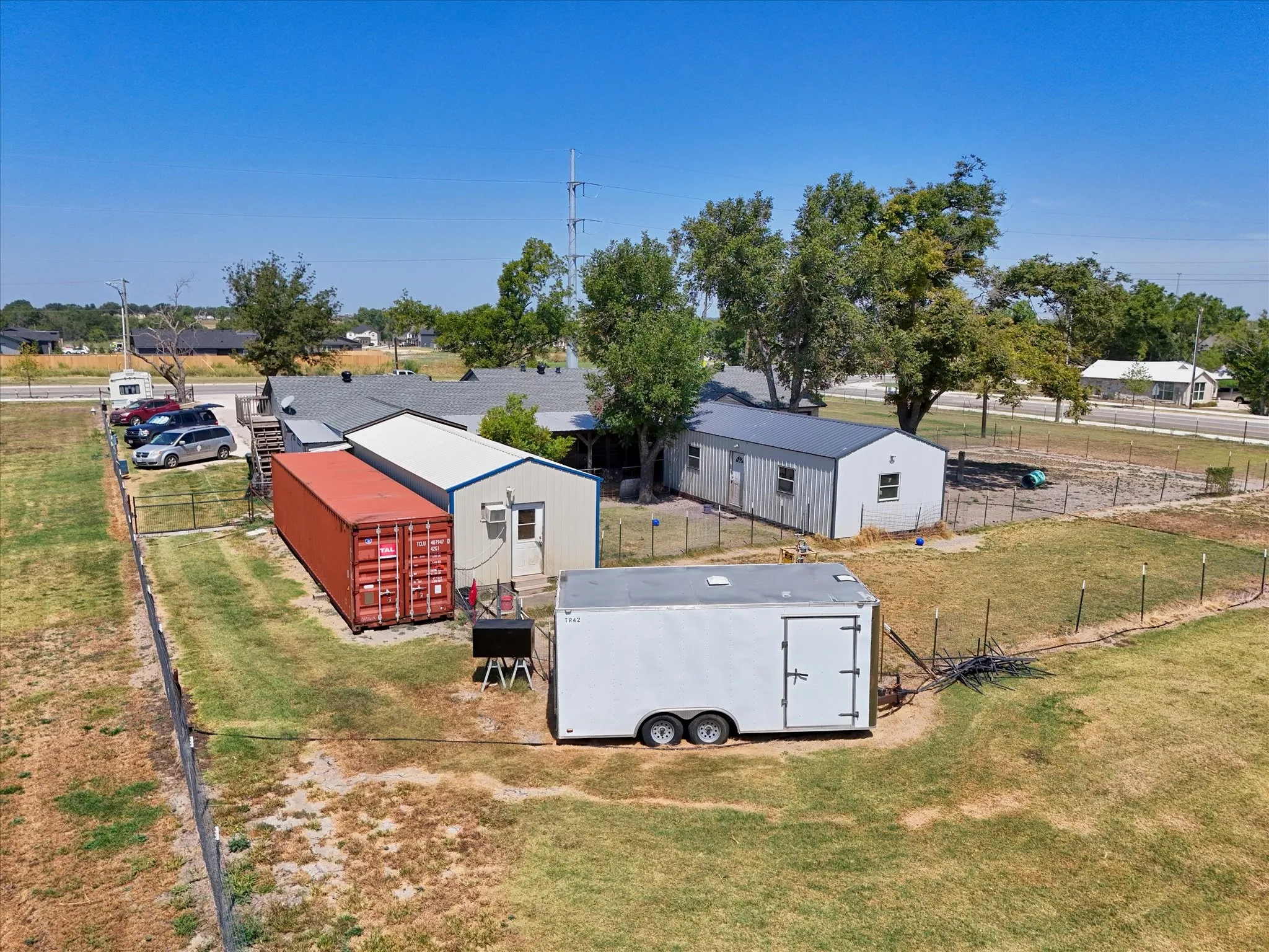 Multiple outbuildings, expansive fenced yard, and paved parking area