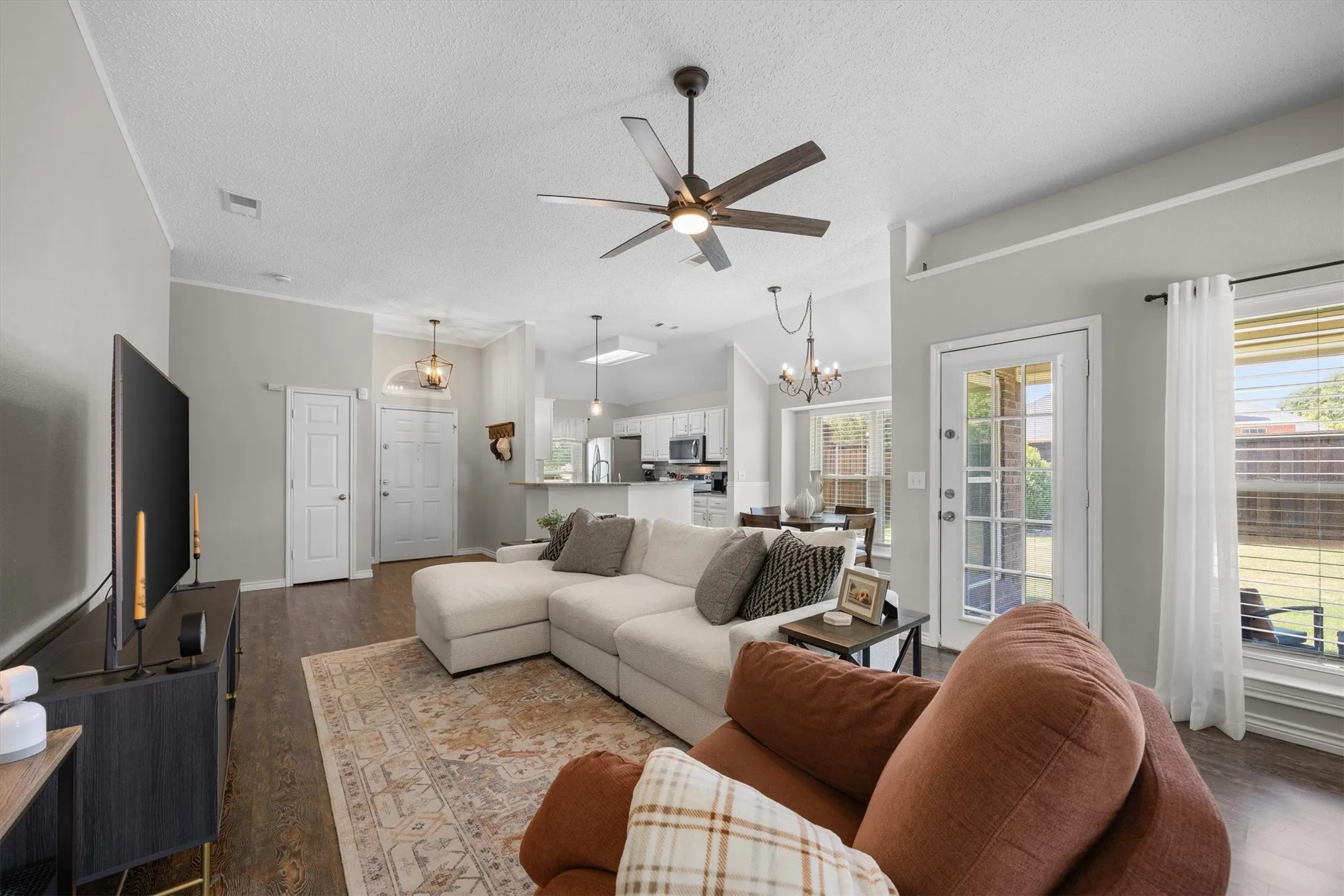 Wood-finish flooring throughout, vaulted ceiling with a ceiling fan,  and a glass-paned exterior door
