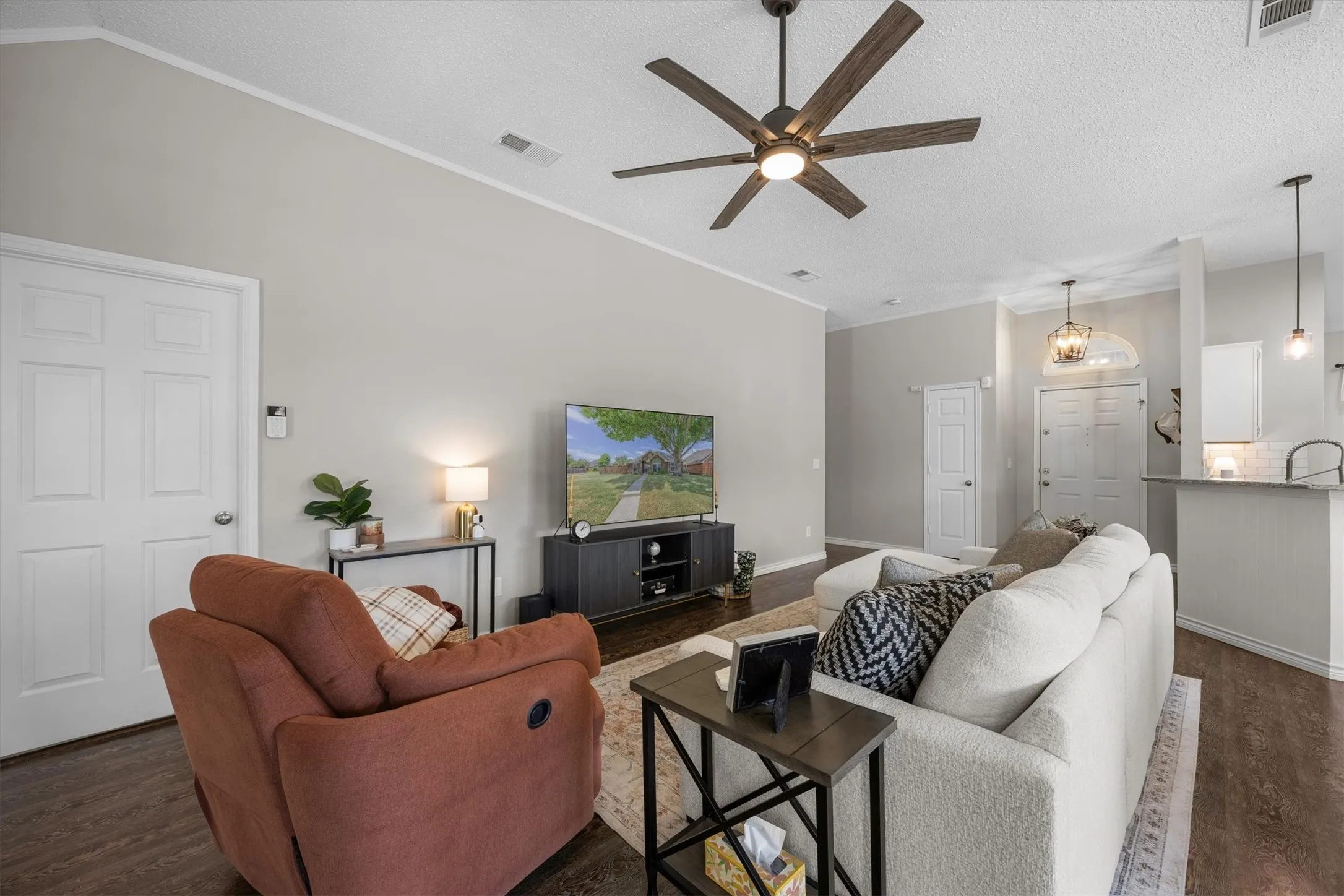 Wood-finish flooring throughout, complemented by a contemporary ceiling fan with integrated lighting