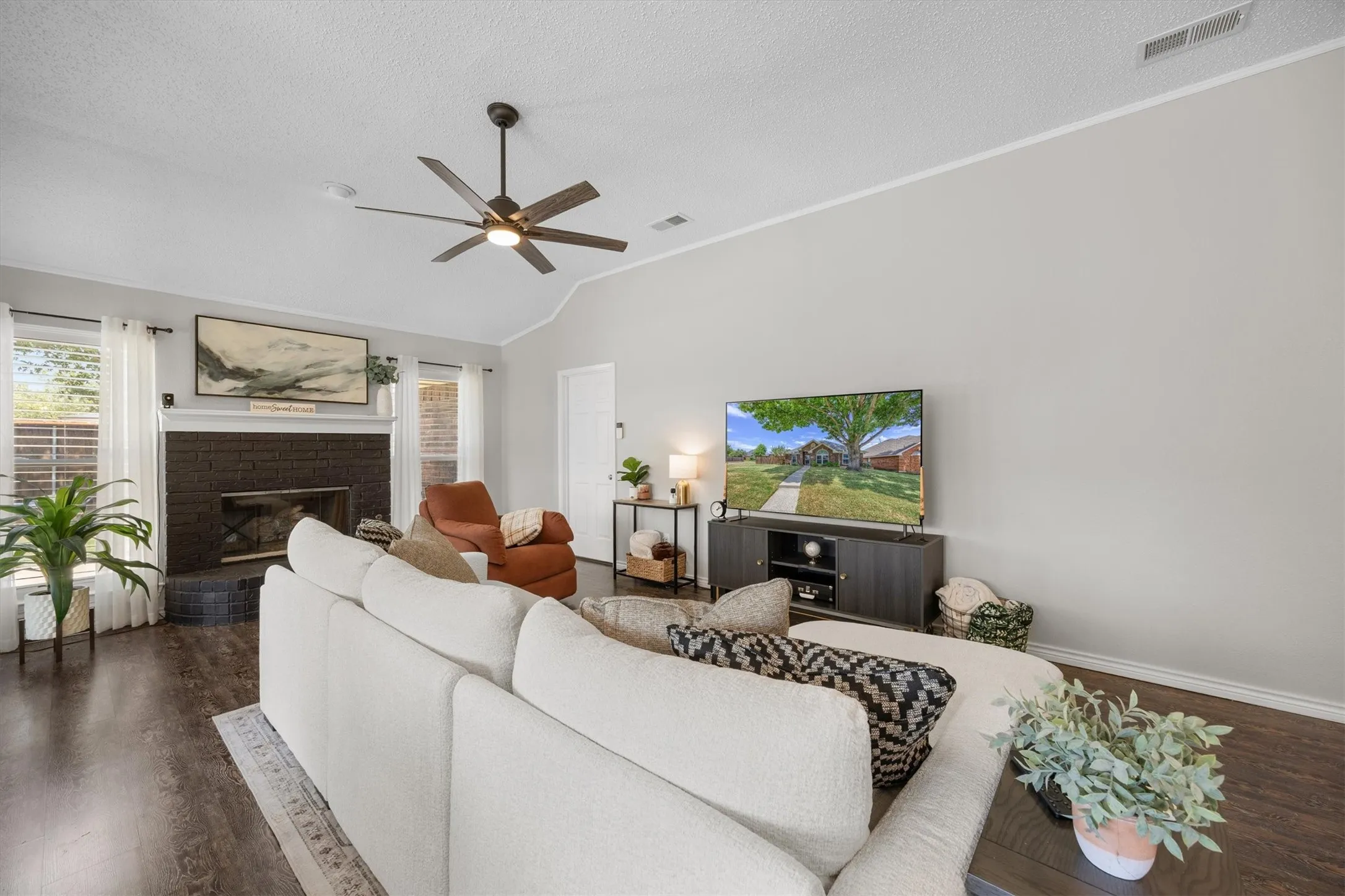 Spacious living room that is focal for home. Handsome fireplace with lots of widows makes this space extra warm and inviting.