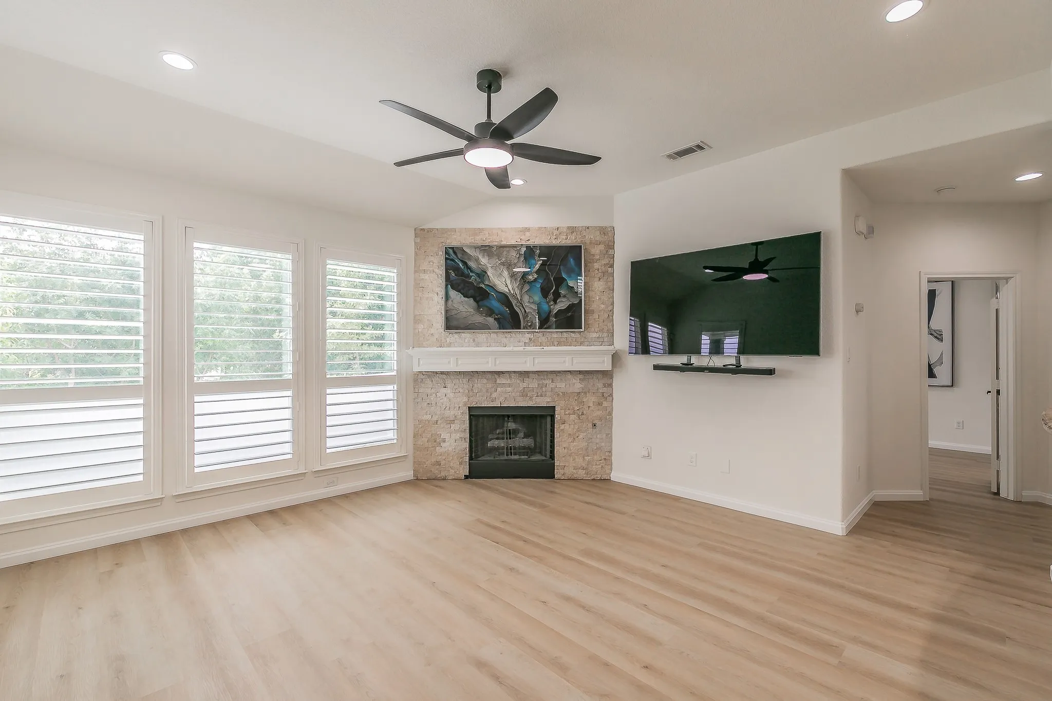 Spacious living room with tons of natural lighting featuring a fireplace