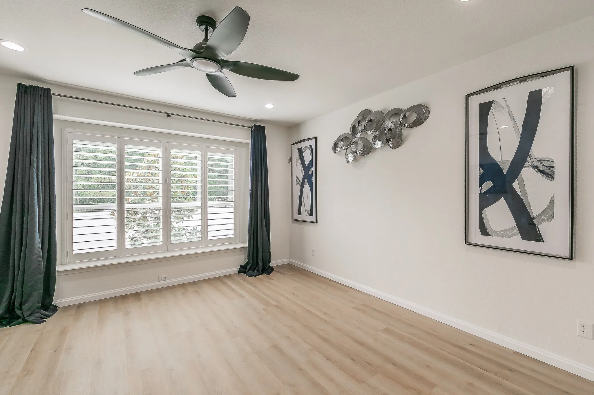 Spacious primary bedroom featuring luxury vinyl plank & a ceilign fan
