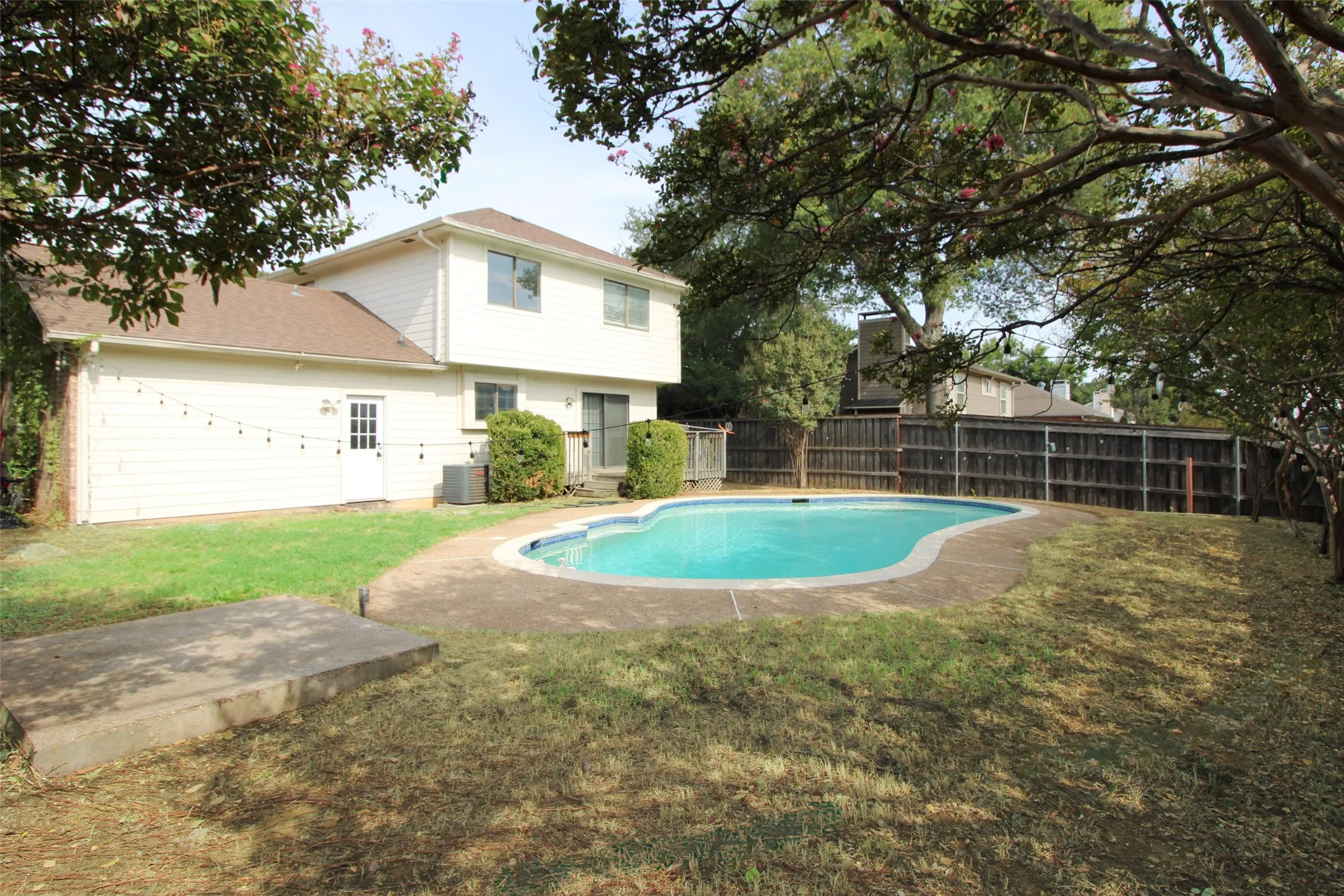 In-ground swimming pool with concrete surround