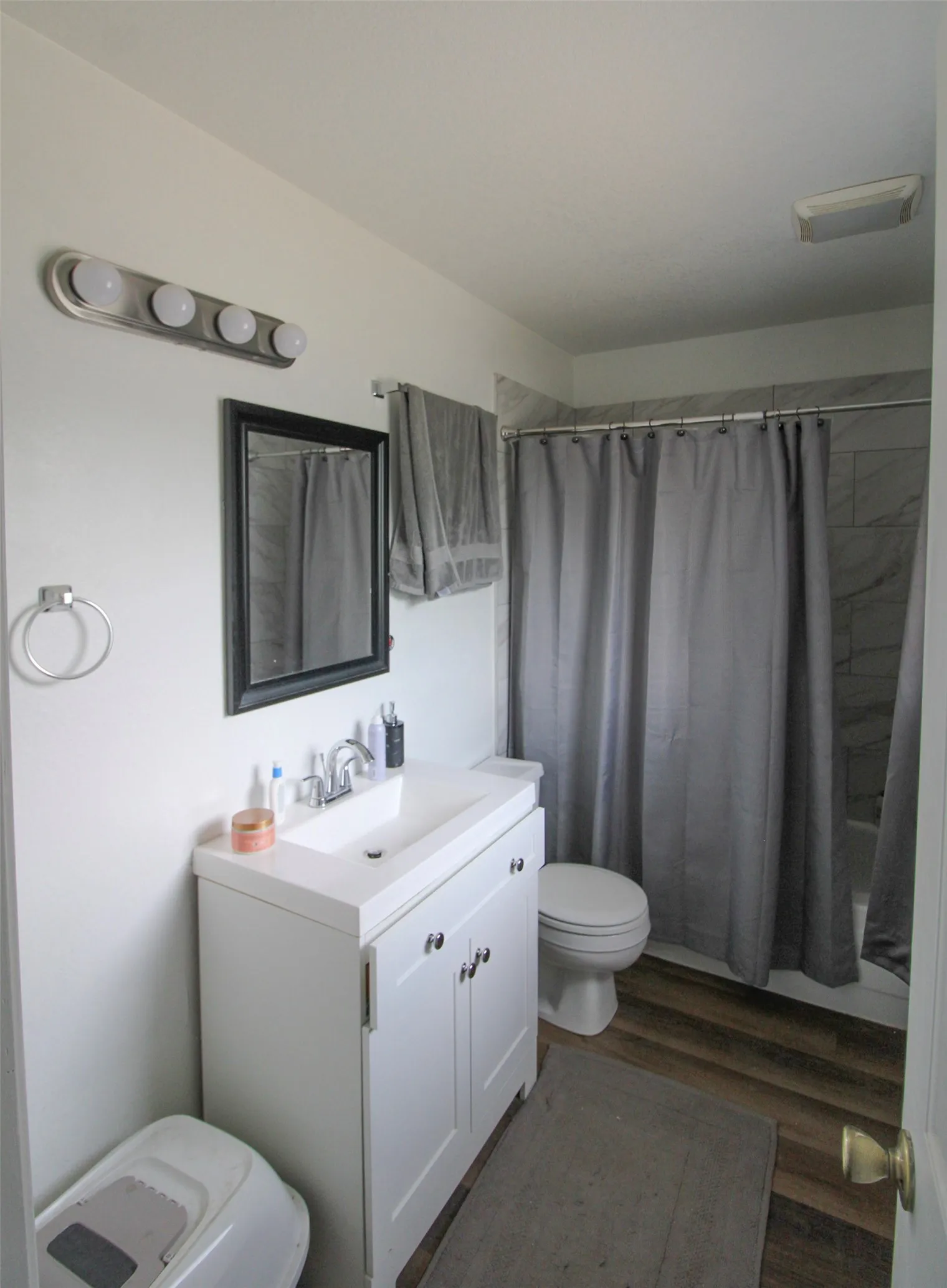 Contemporary bathroom featuring a white vanity with multiple storage drawers, rectangular vessel sink, and polished chrome fixtures