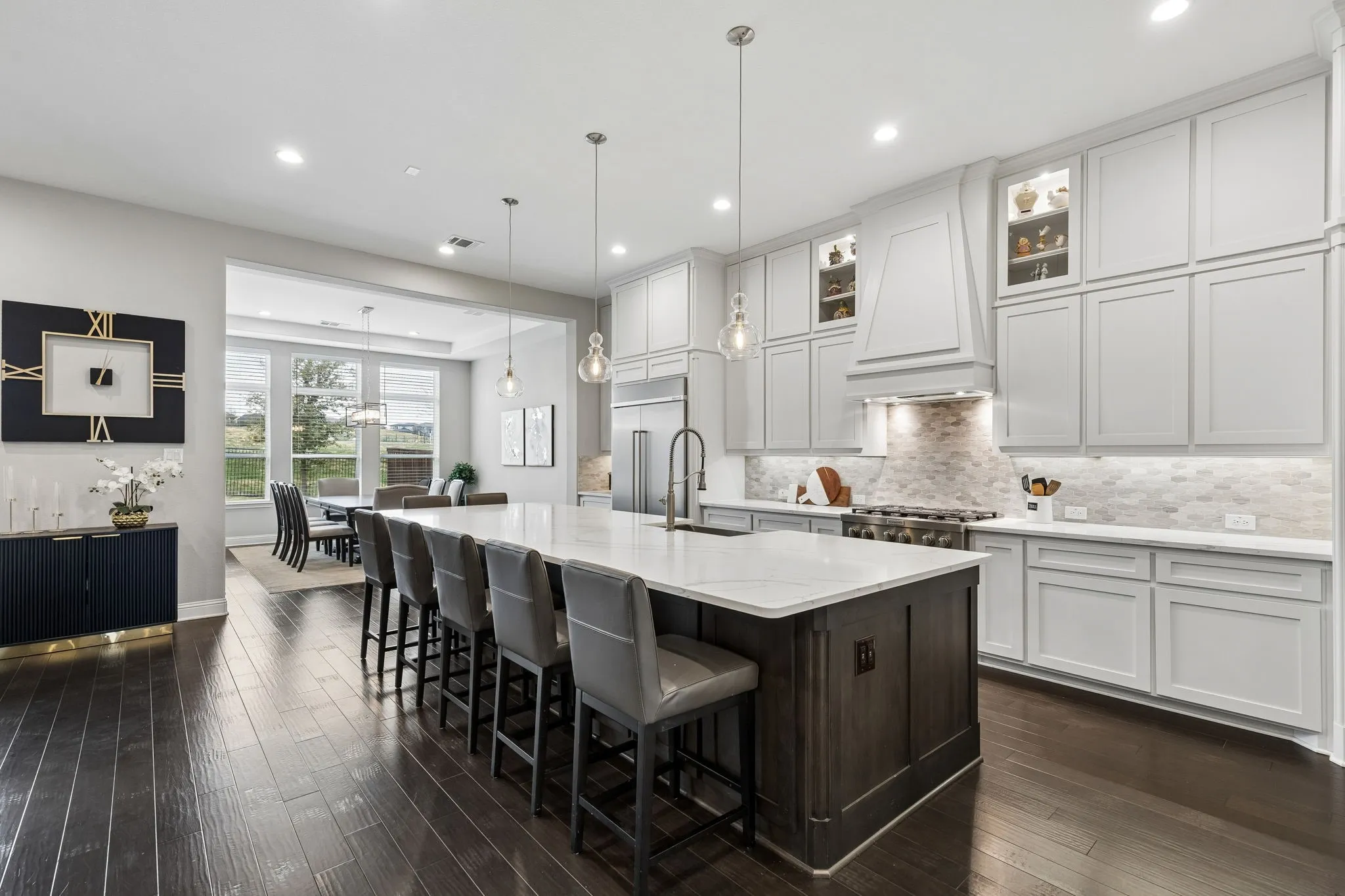 Large island with Quartz countertops, commercial grade appliances and cabinets up to the ceiling