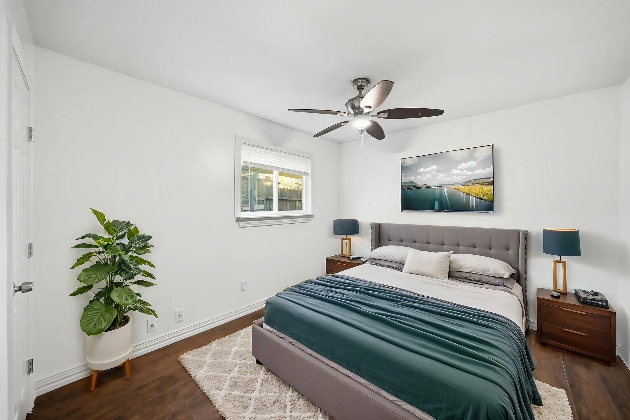 Recessed window with blinds, wood-finish flooring, and a ceiling fan with integrated lighting