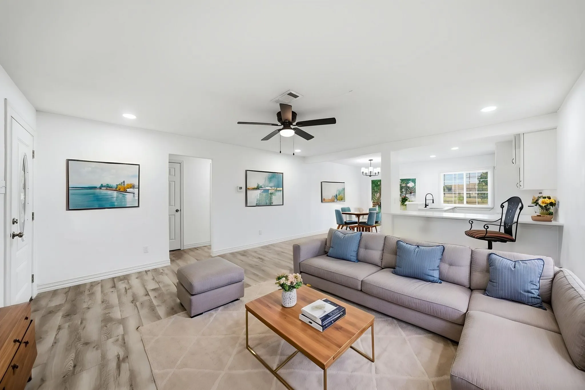 Open-concept living space featuring wood-finish flooring, recessed lighting, and a ceiling fan
