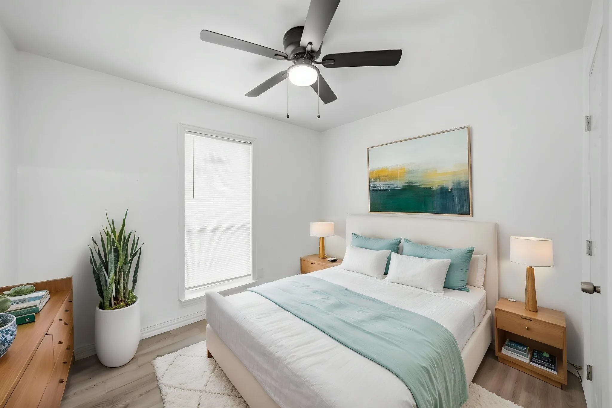 Recessed window with roller shade, overhead ceiling fan with light, wood-finish flooring, and light-toned walls